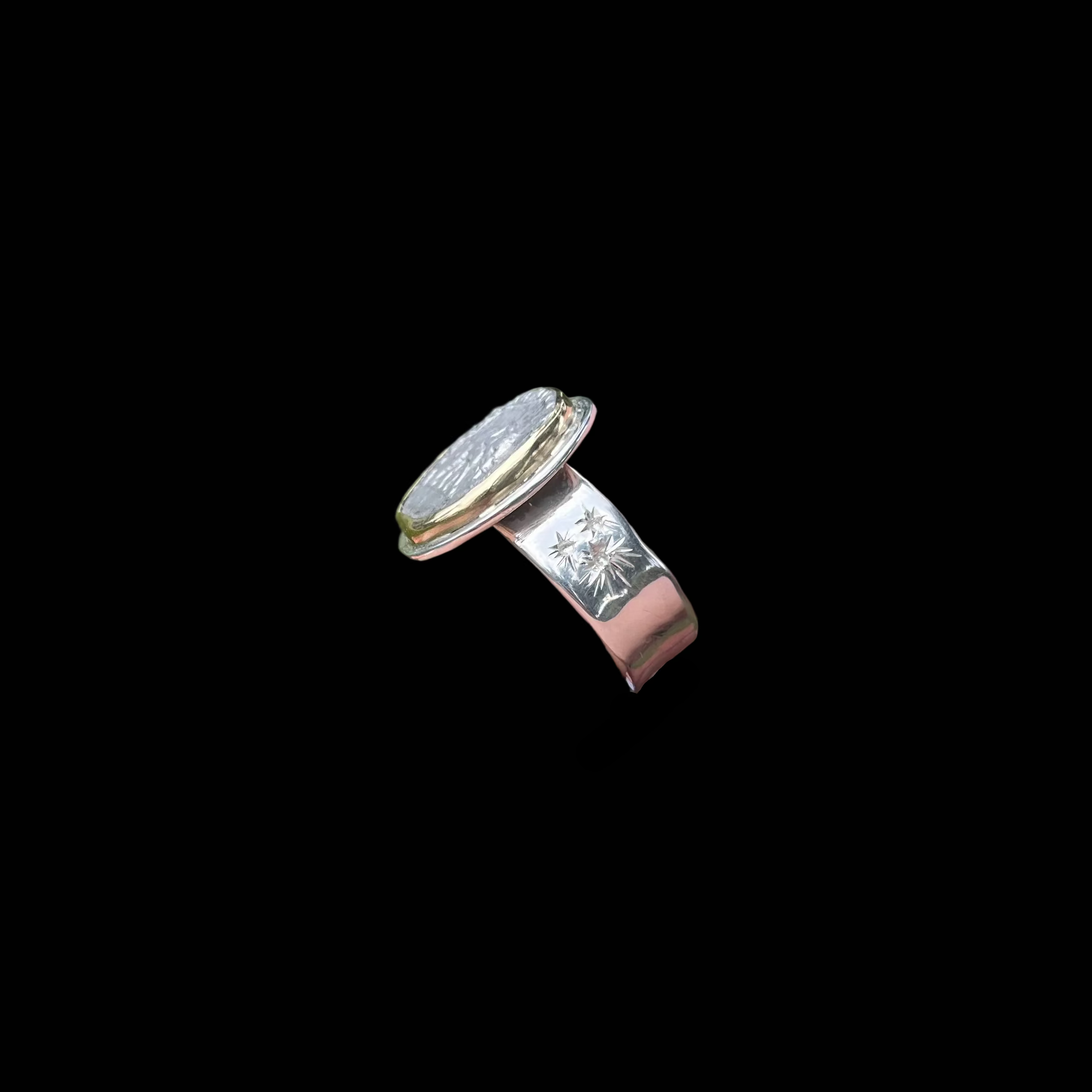 side view of ring with wide band shown on black background