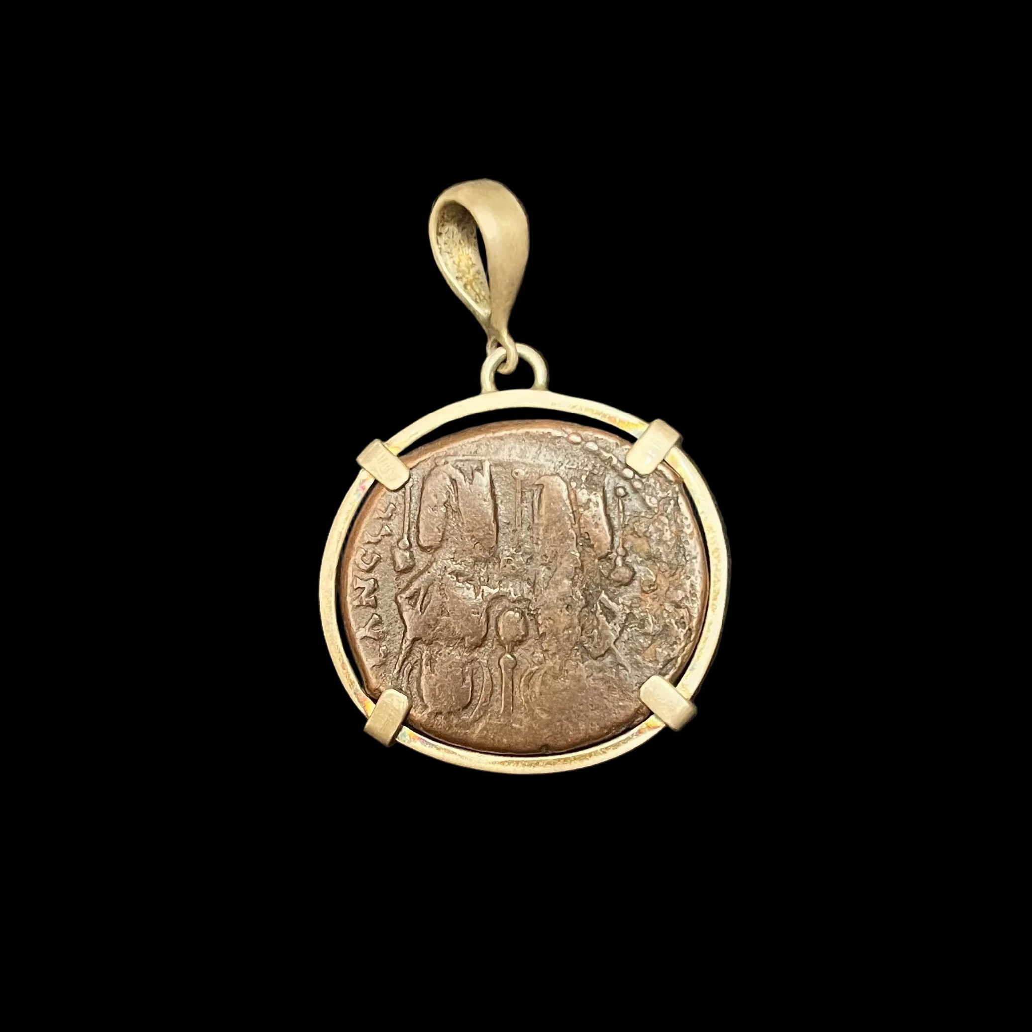 Bronze pendant with a coin insert on a black background