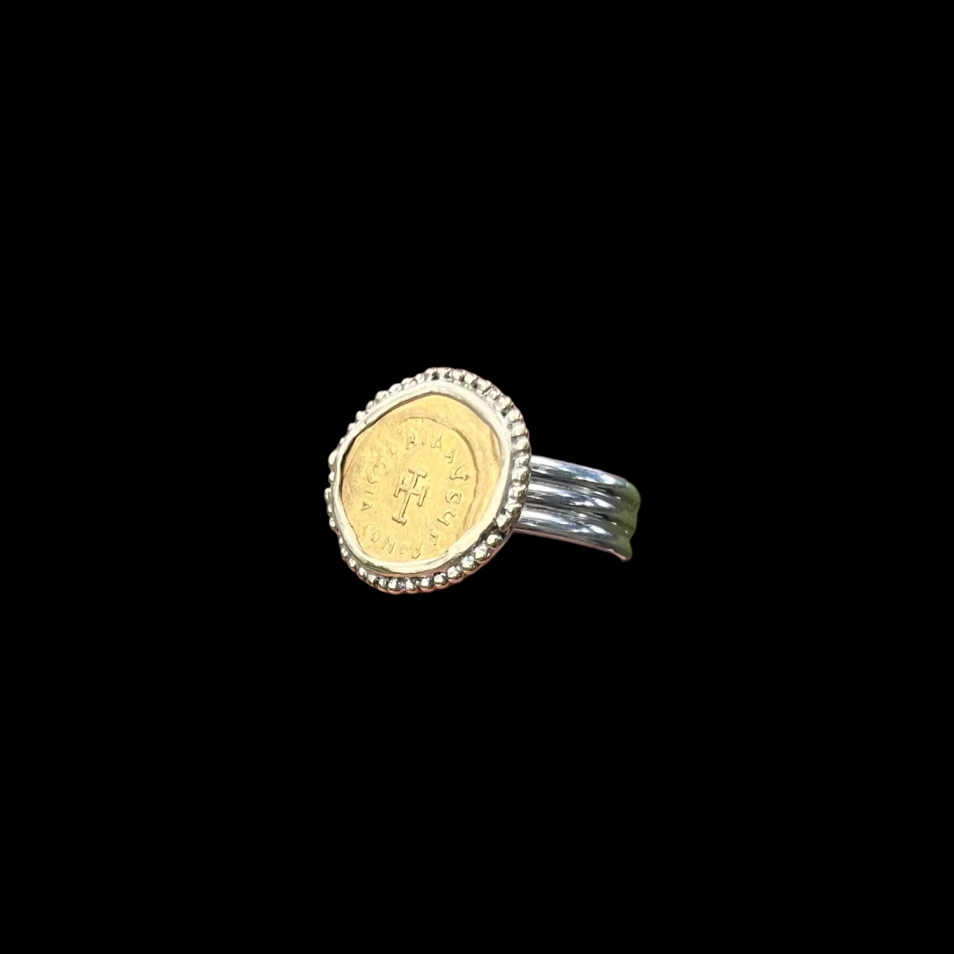 Gold ring with silver band on black background