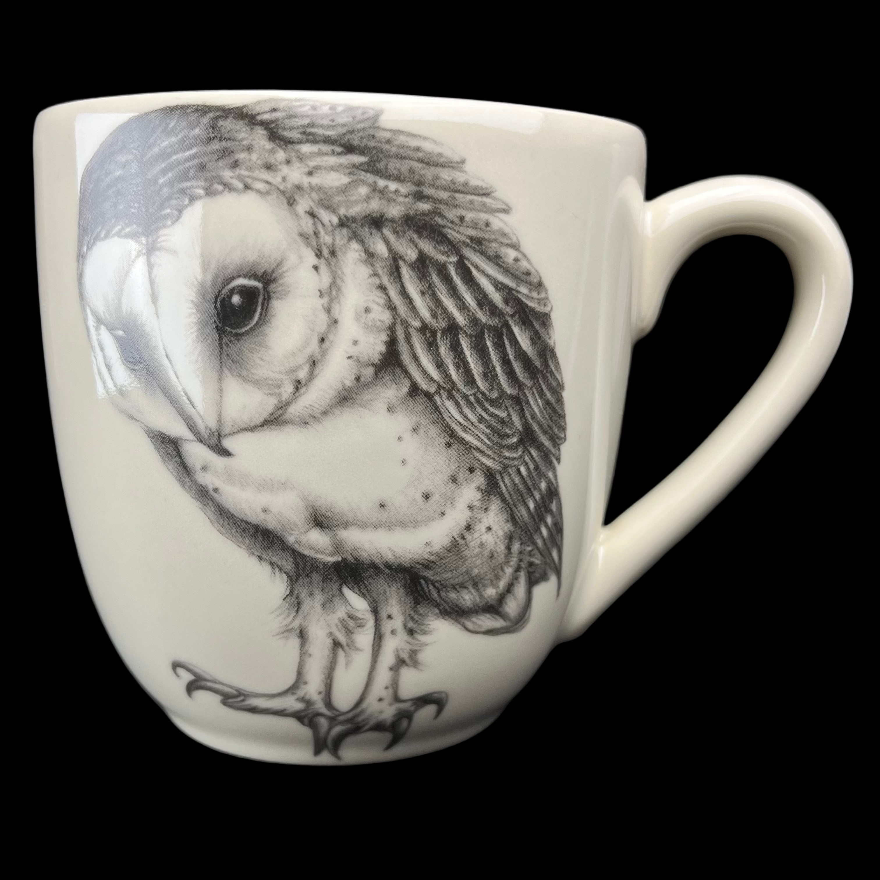 White mug with black and white owl design on a dark background