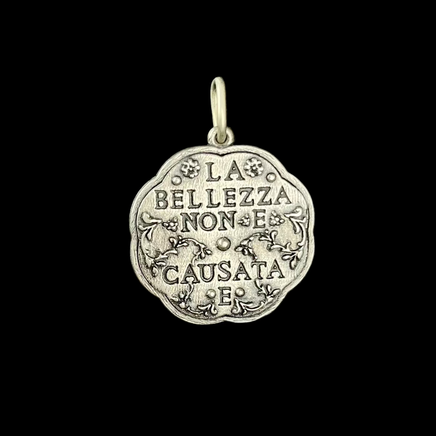 Silver charm with stamped Italian words on black background