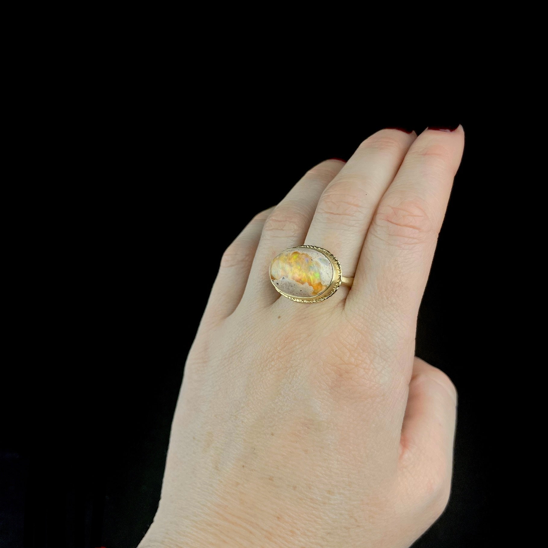 Front view of Gold Fire Opal ring worn on hand