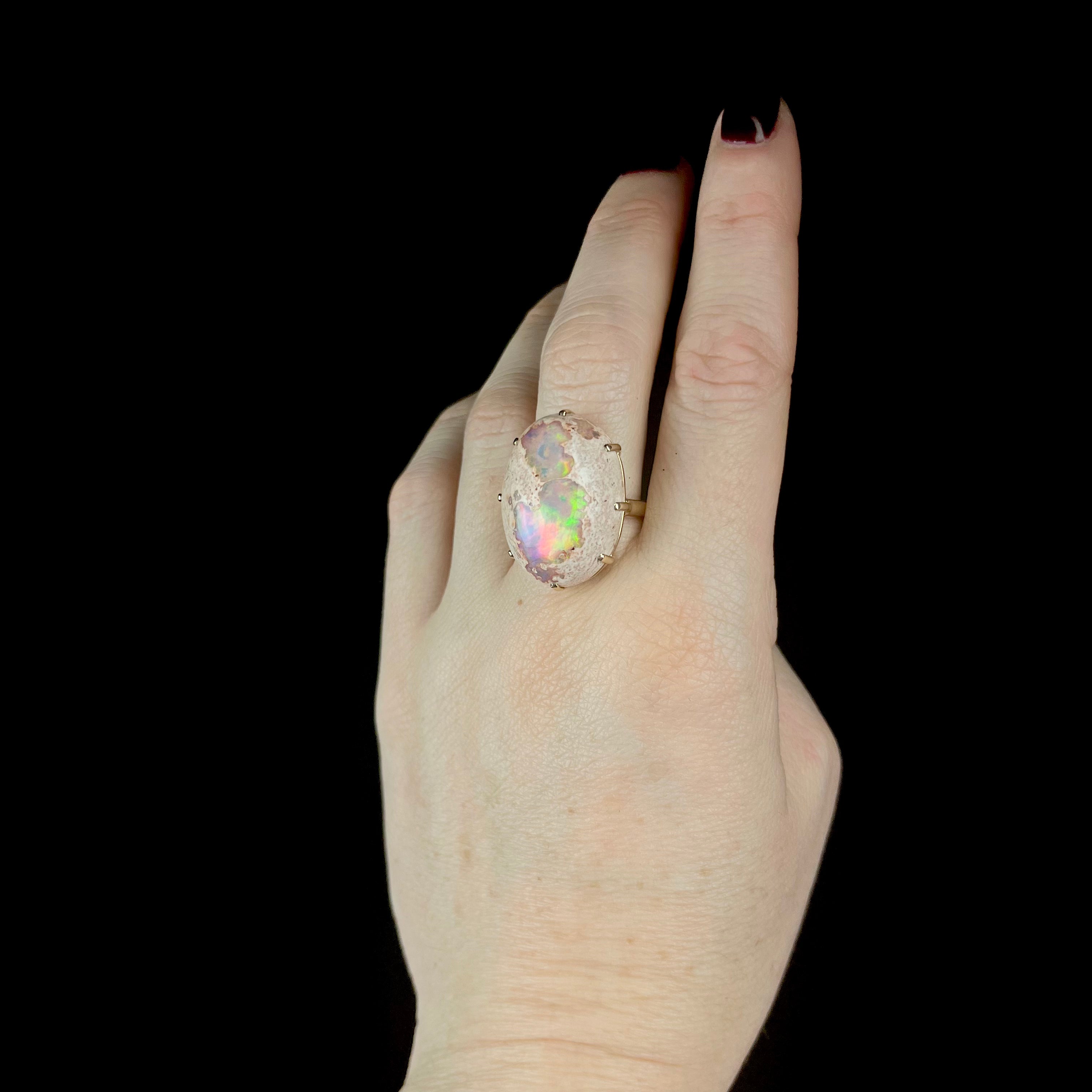 Side view of Fire Opal ring on hand