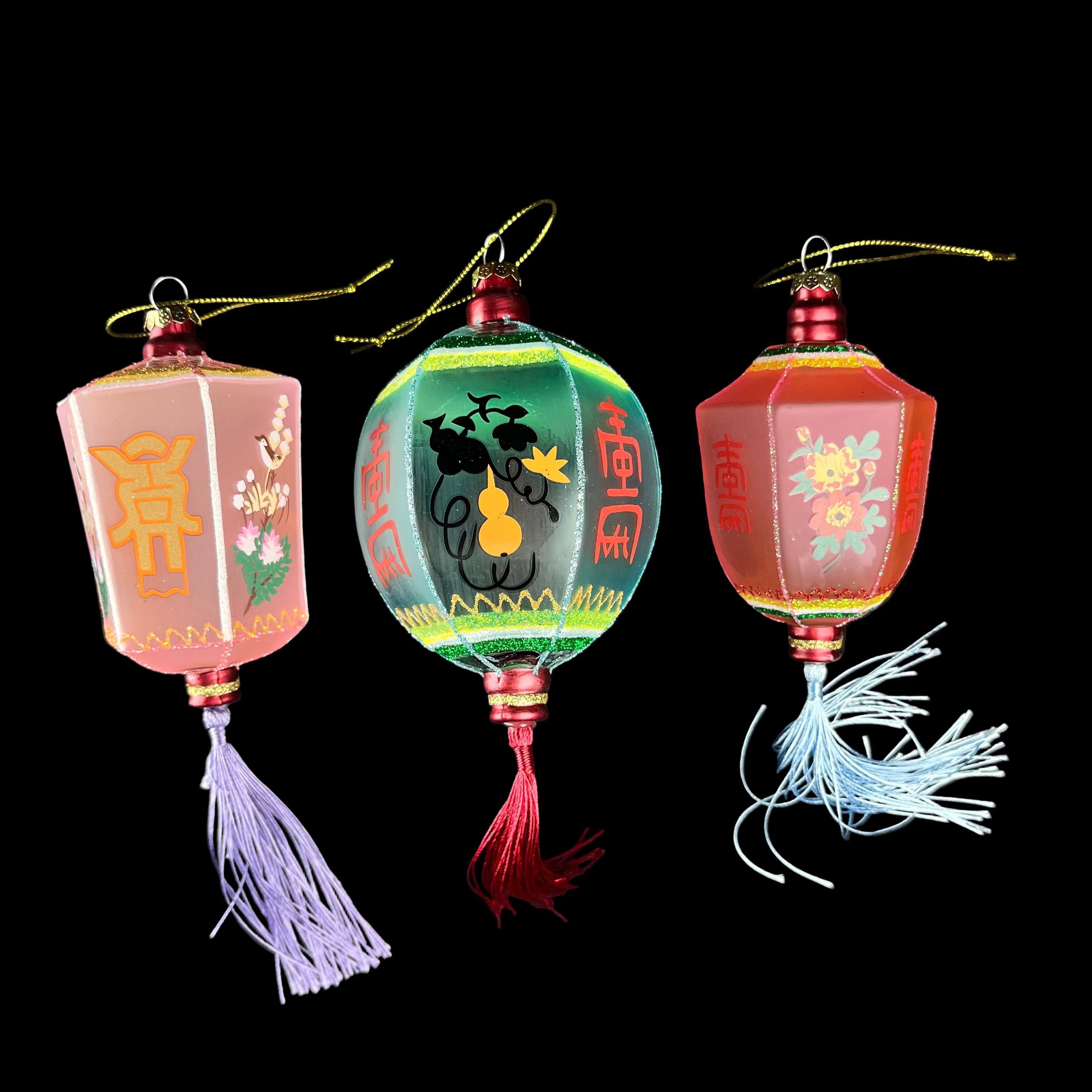 Three decorative lantern ornaments with tassels on a black background