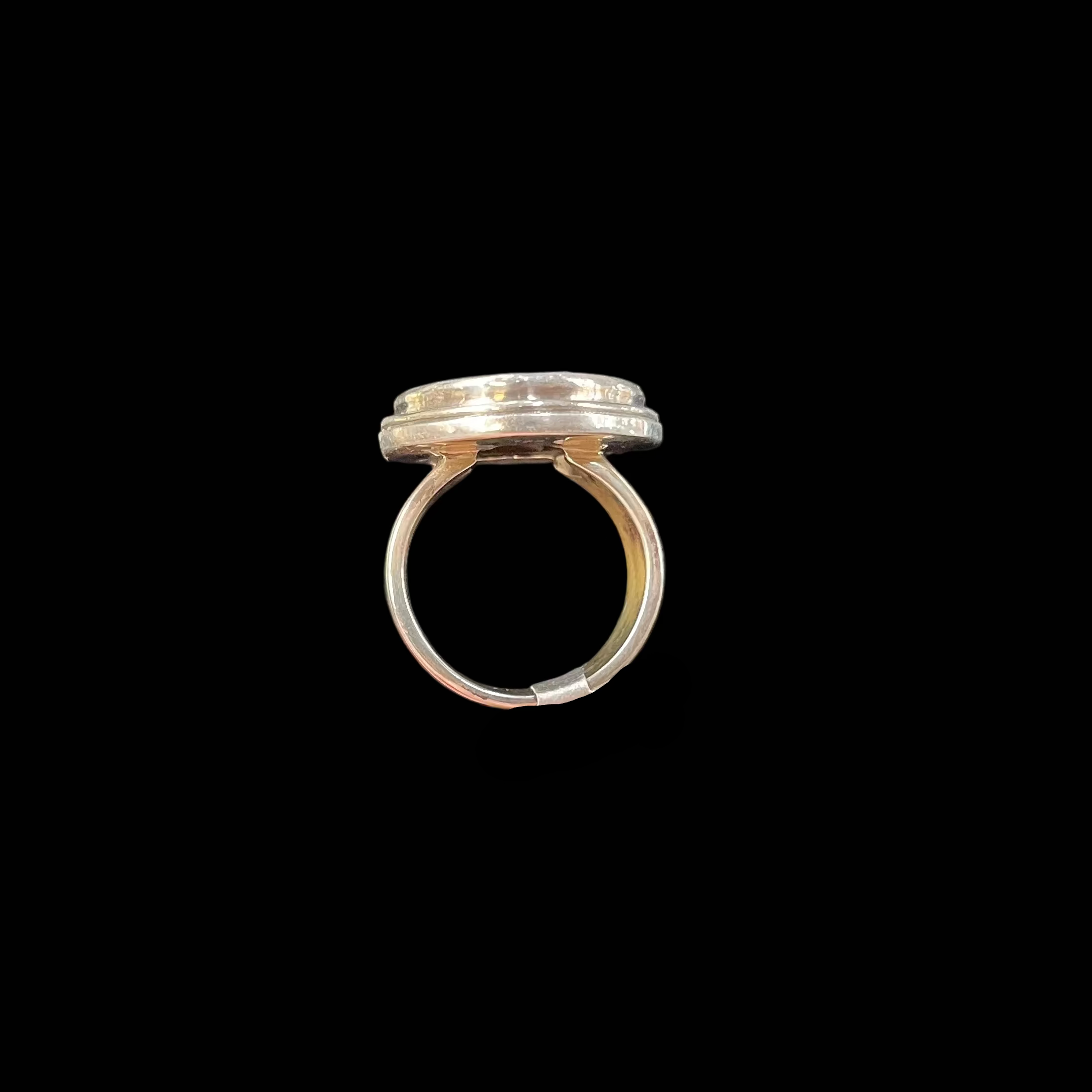 Silver ring against a black background