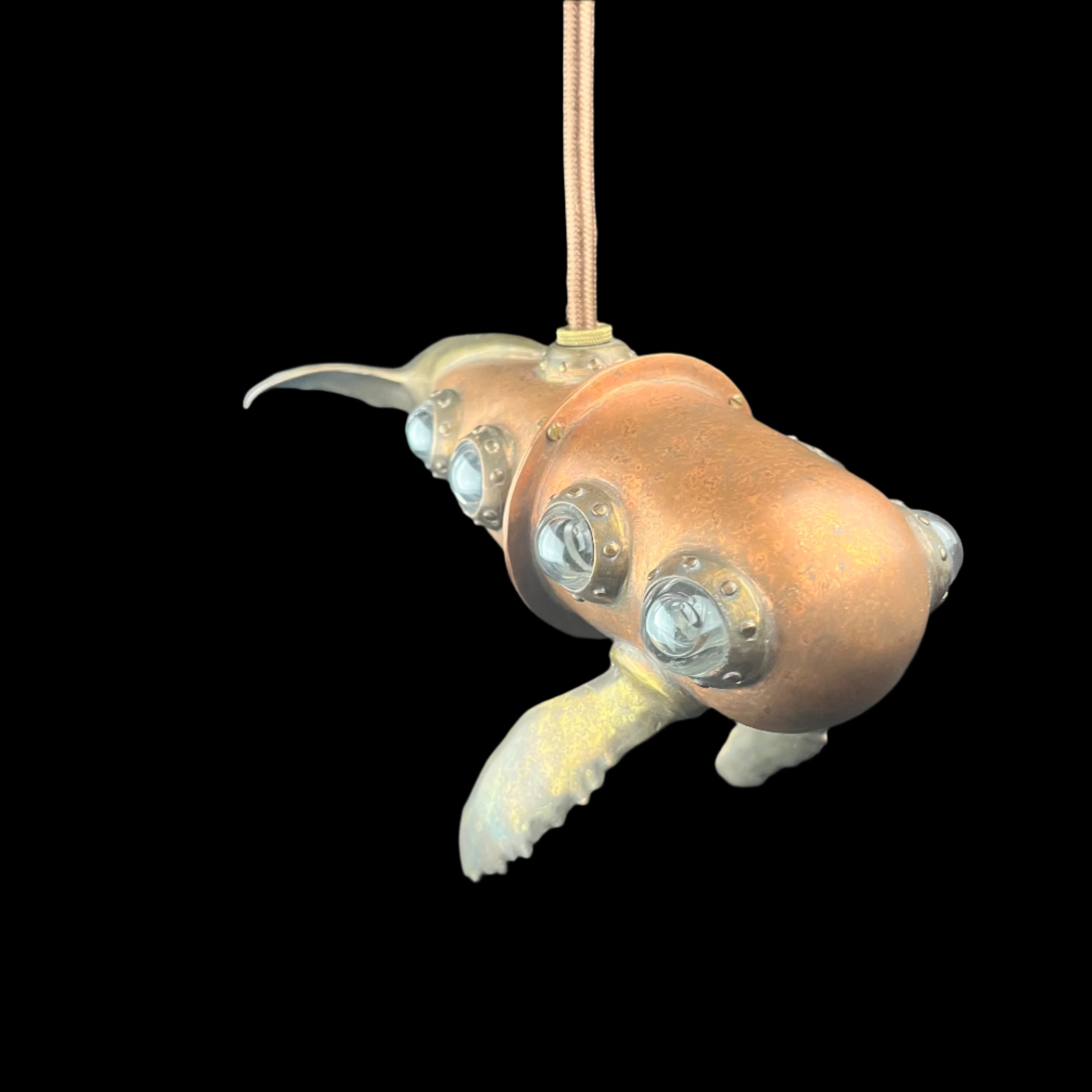 Decorative metal sea creature with glass eyes on a dark surface