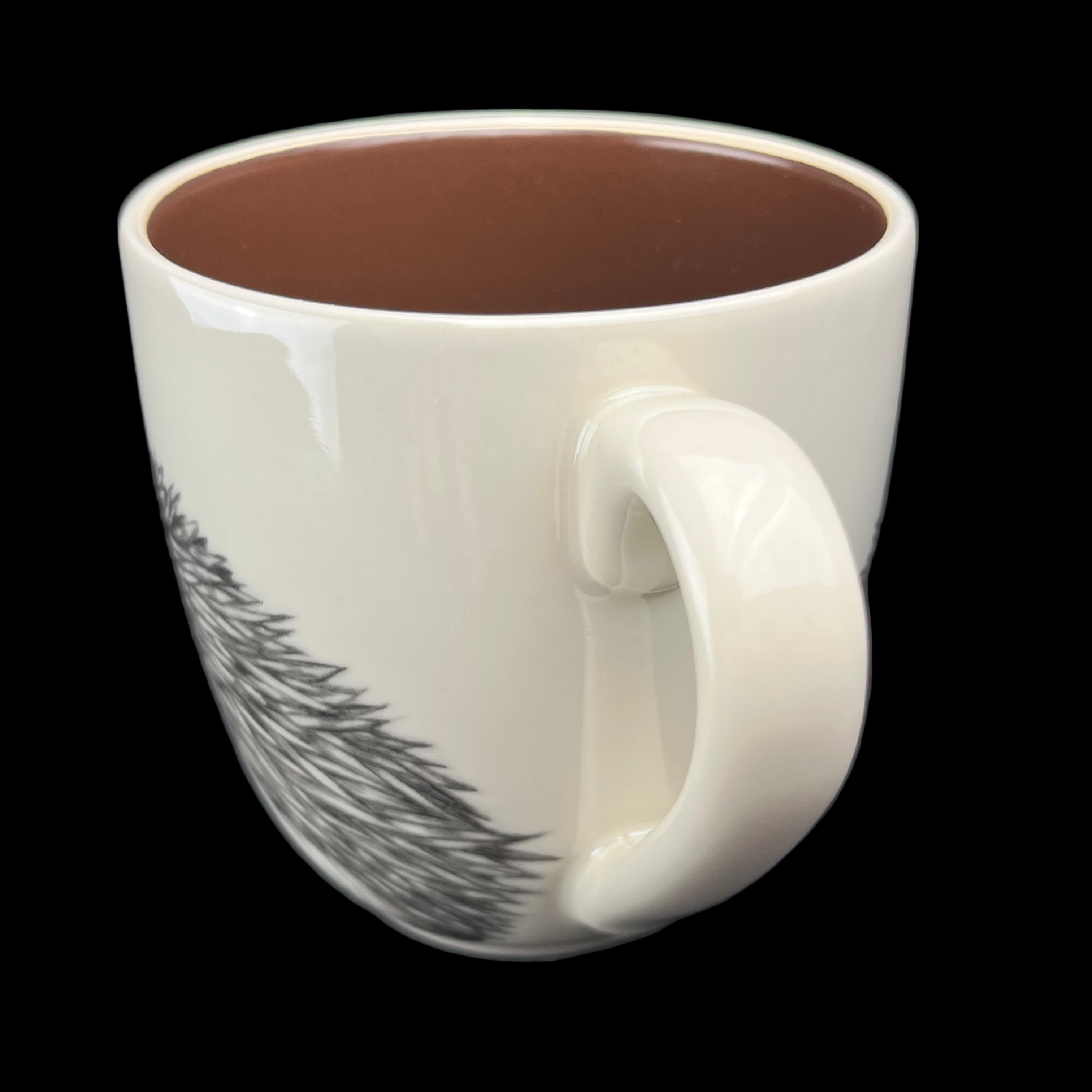 White mug with a handle and black design on a dark background