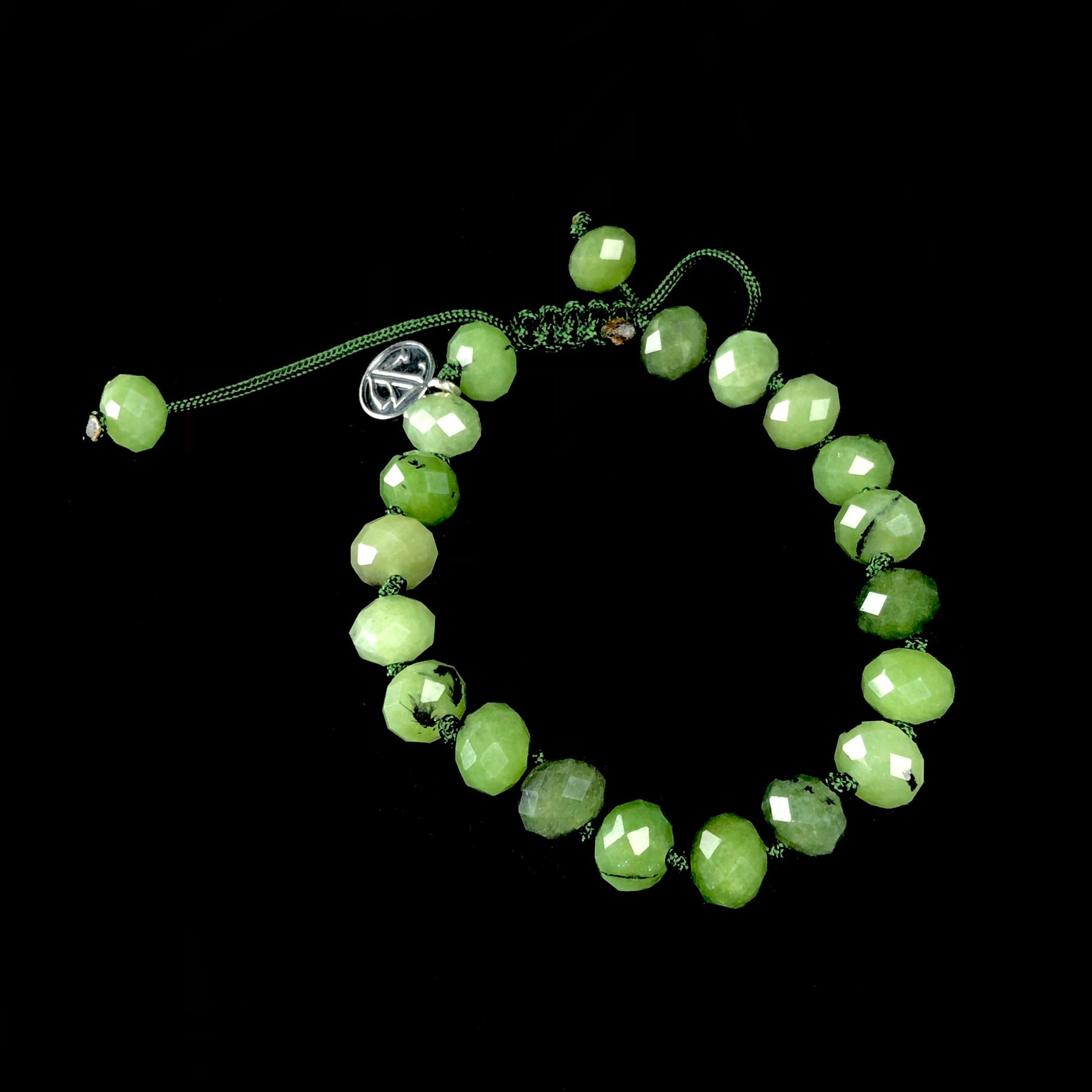 Opaque forest green colored bead bracelet knotted with dark green cord.