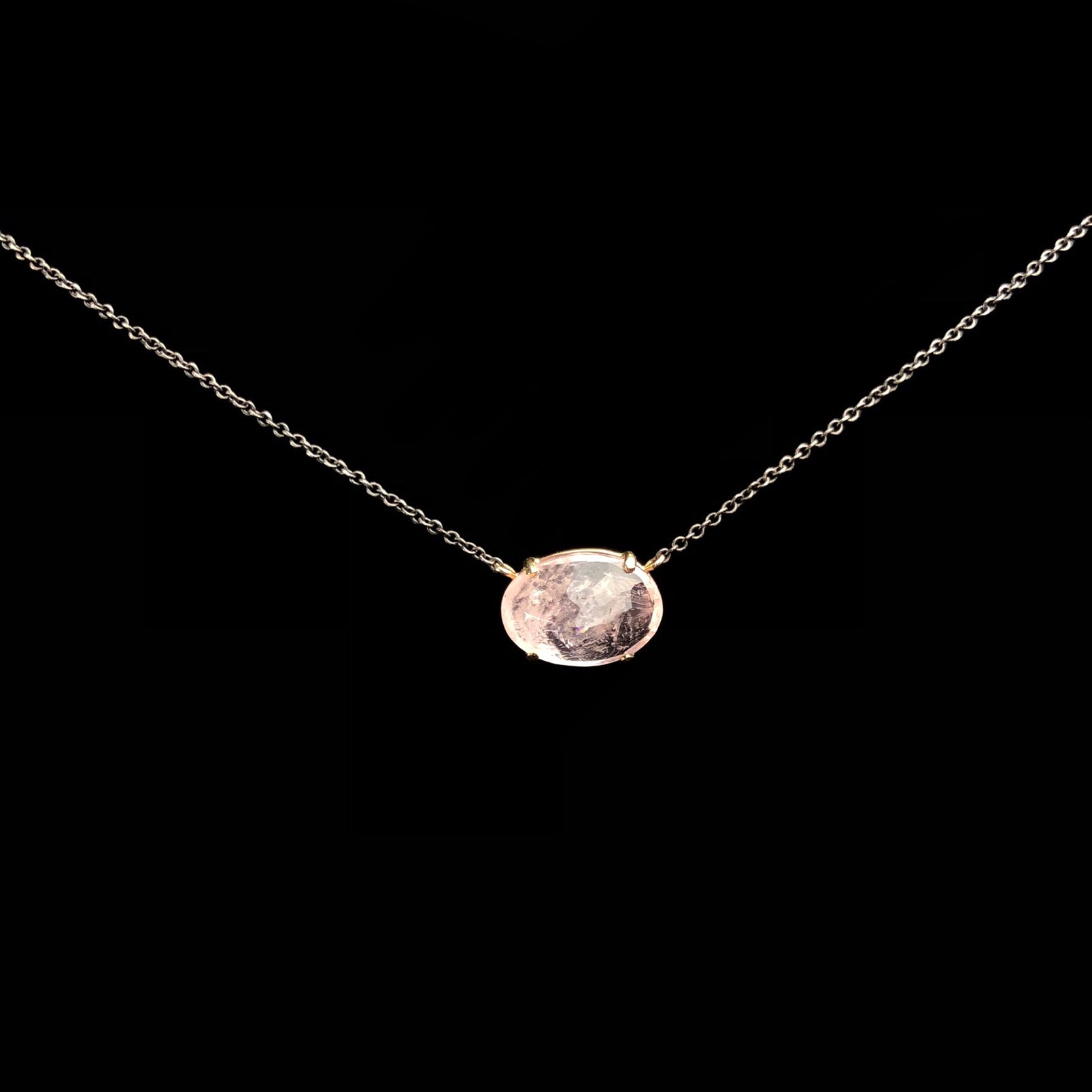 Transparent pink stone with gold prong setting on blackened silver chain