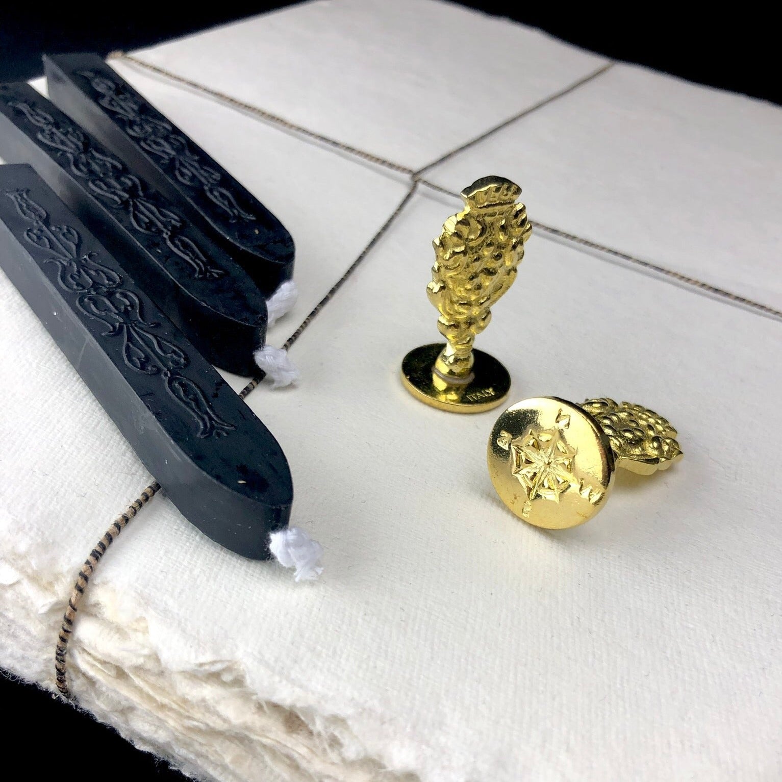 Seal sitting on cotton paper with black sealing wax beside it