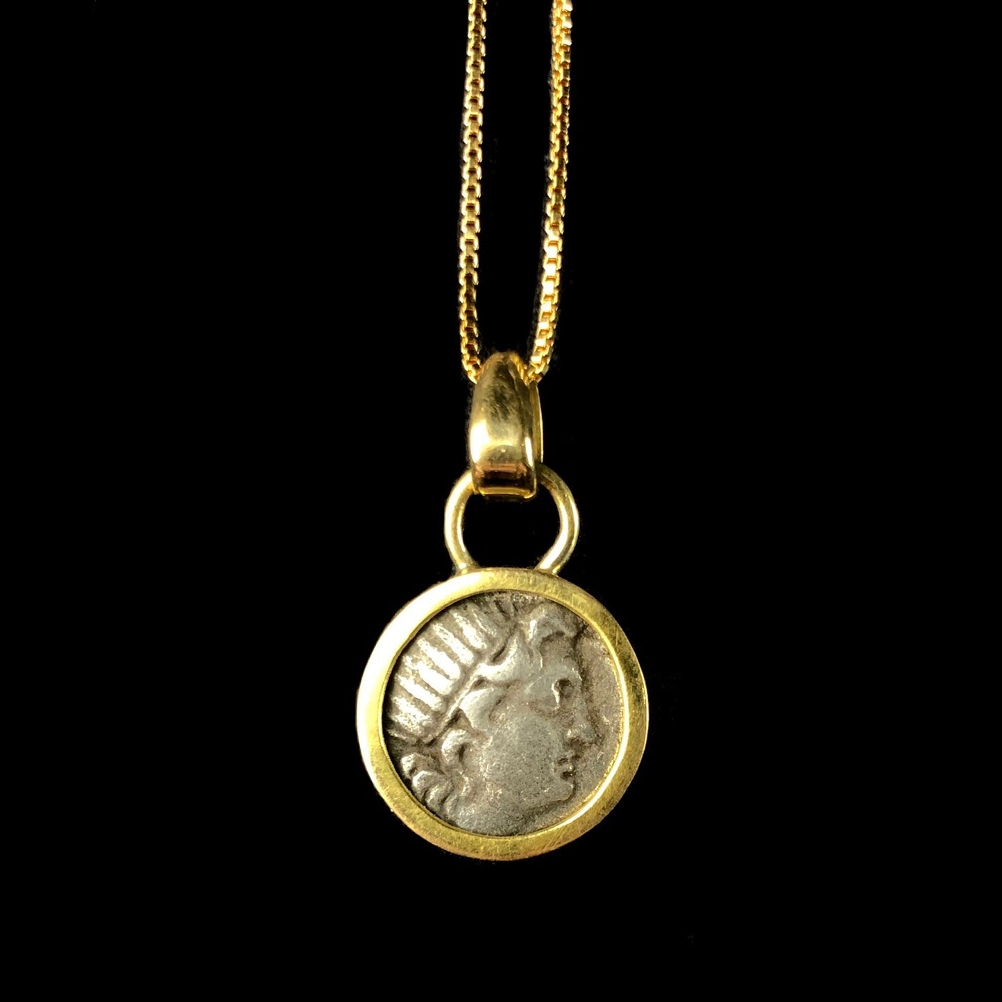 The radiate head of Helios in silver with gold setting