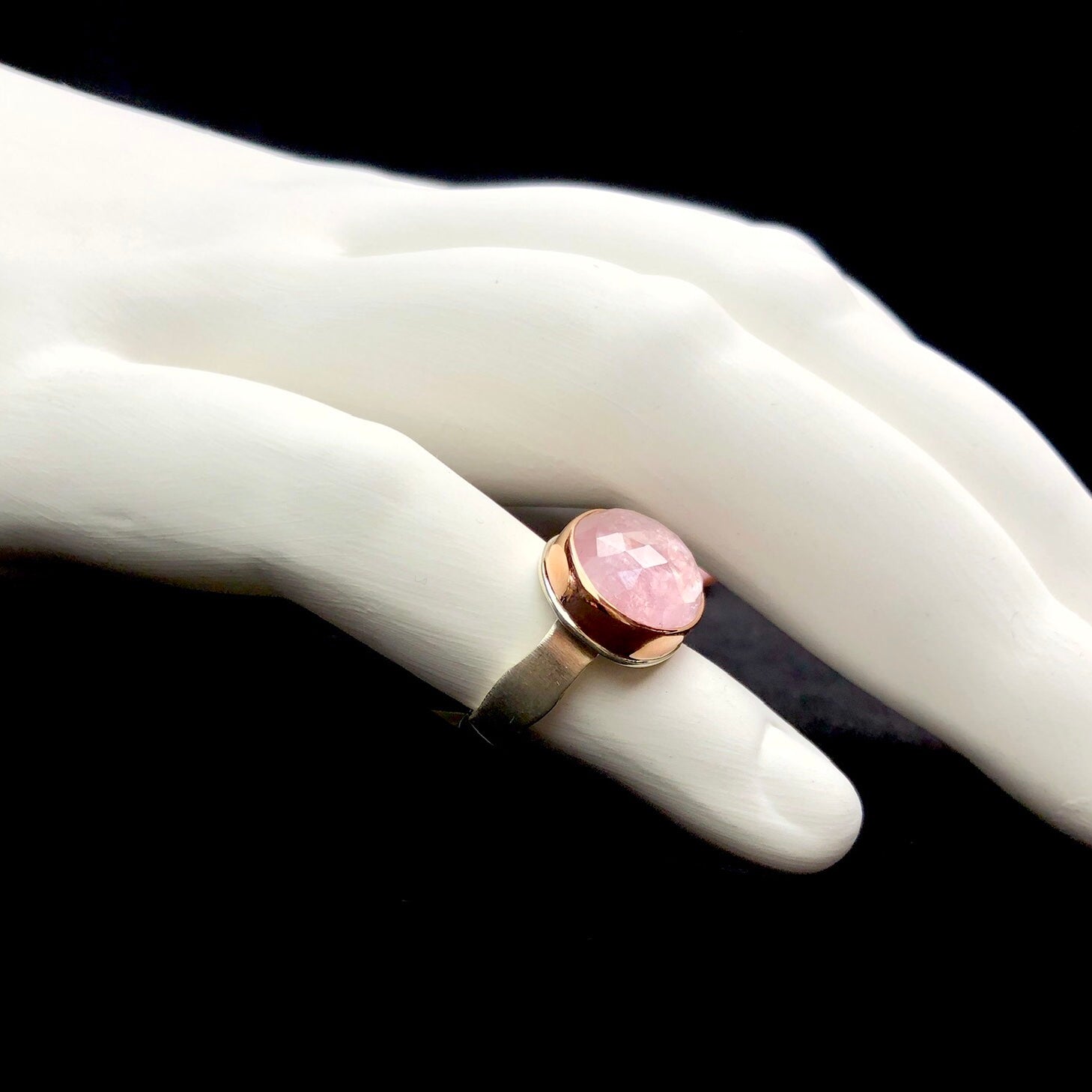 Side profile view of morganite ring on white ceramic sculptured oversized finger