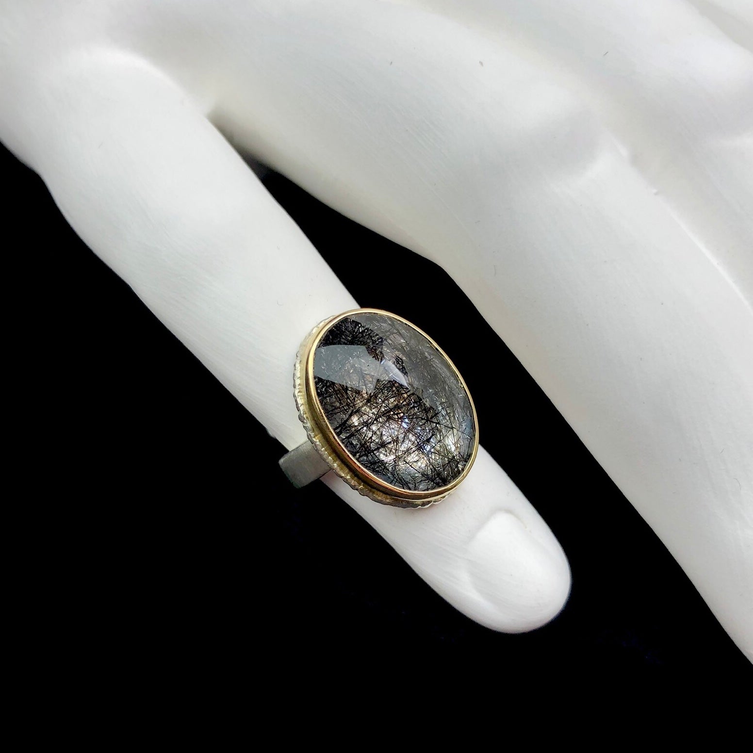 Tourmalinated quartz ring shown on white ceramic finger