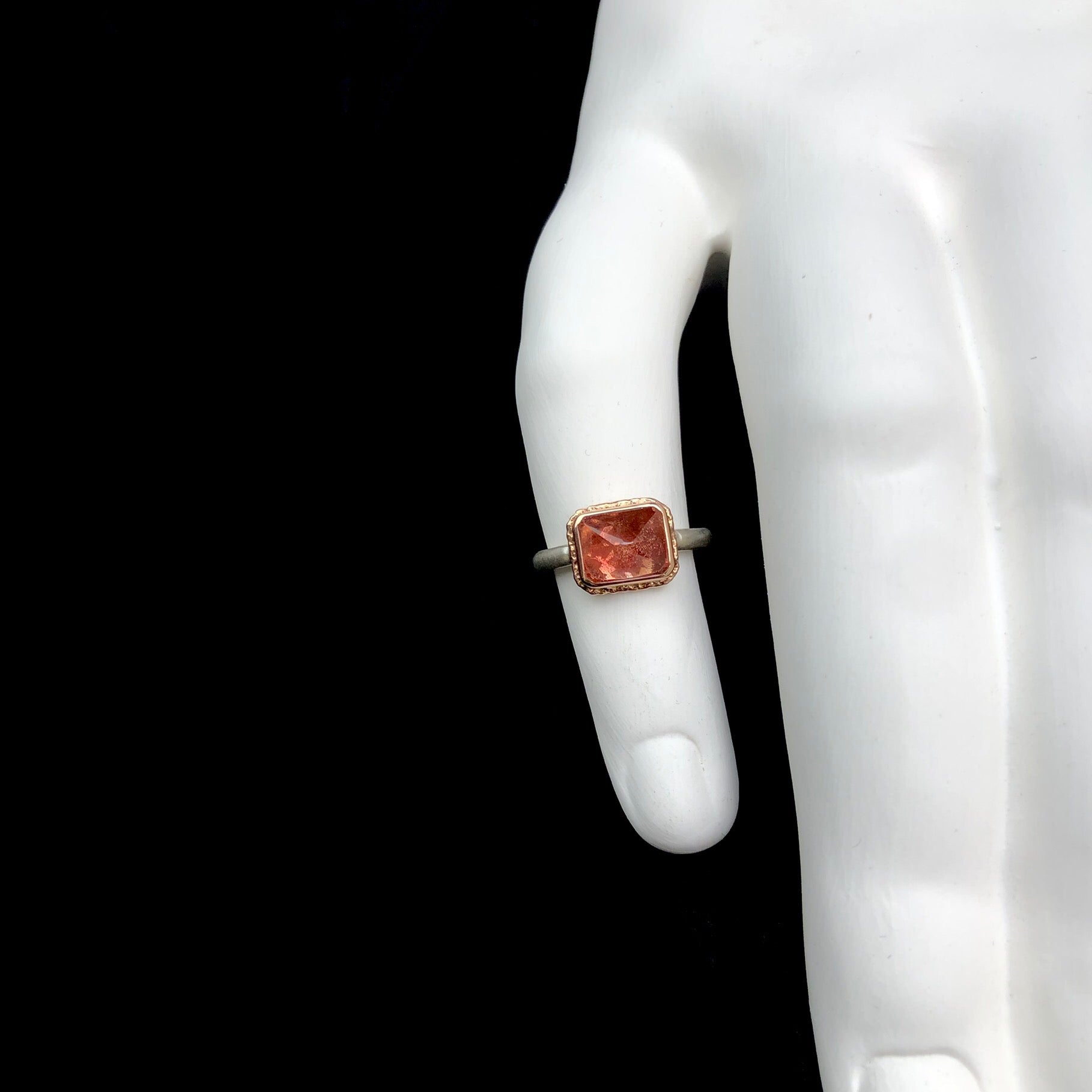 Oregon sunstone ring shown on white ceramic finger