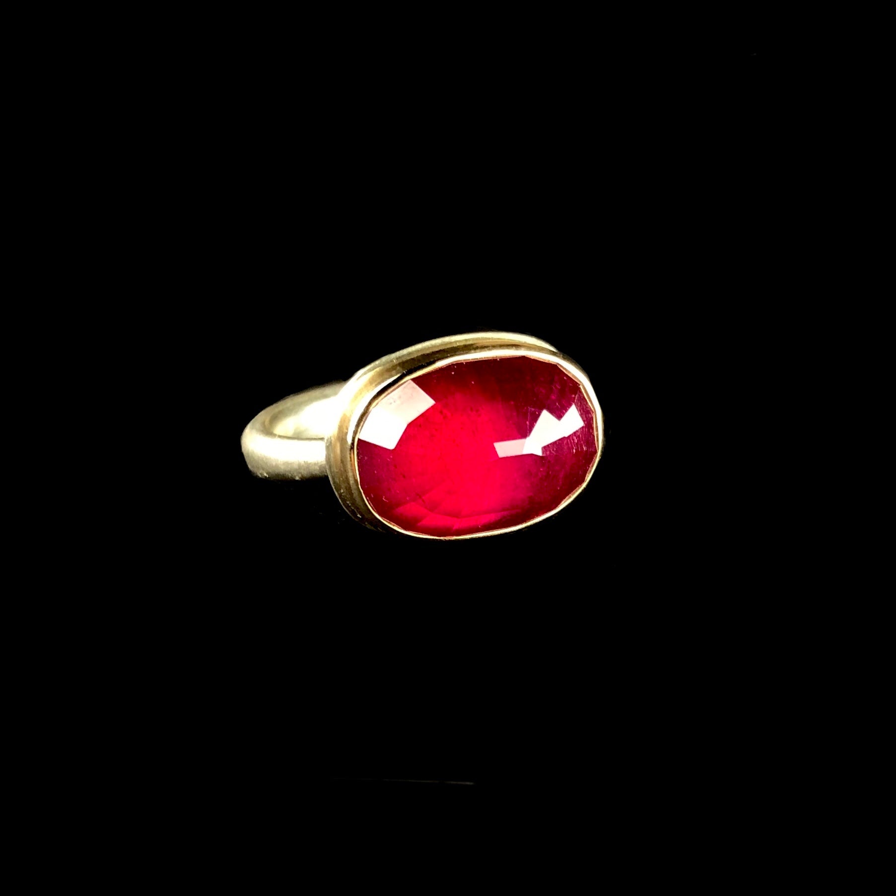 Oval shaped, faceted deep pink/red colored ruby stone ring 