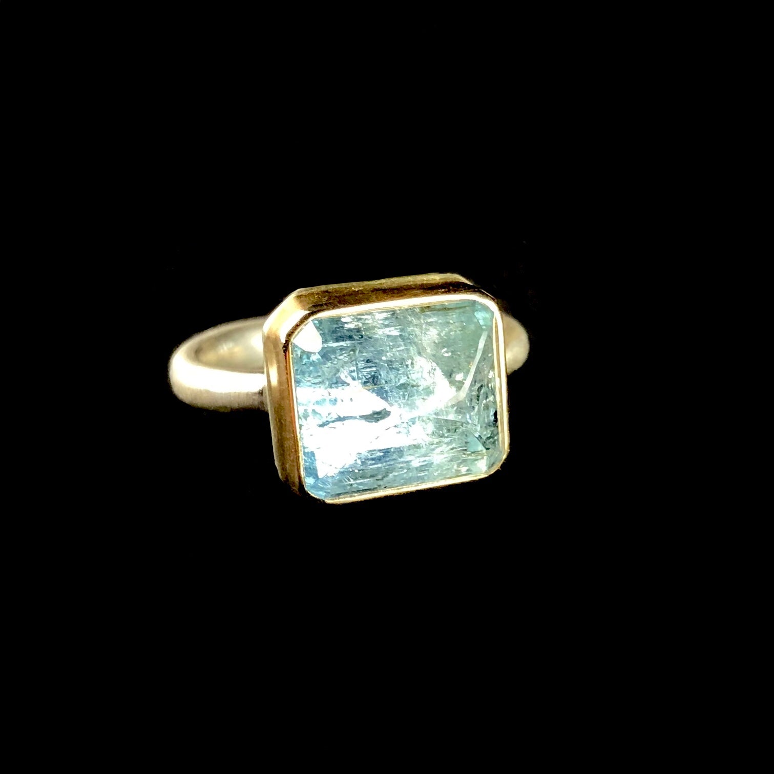 Front side view of rectangular shaped, light blue aquamarine stone ring