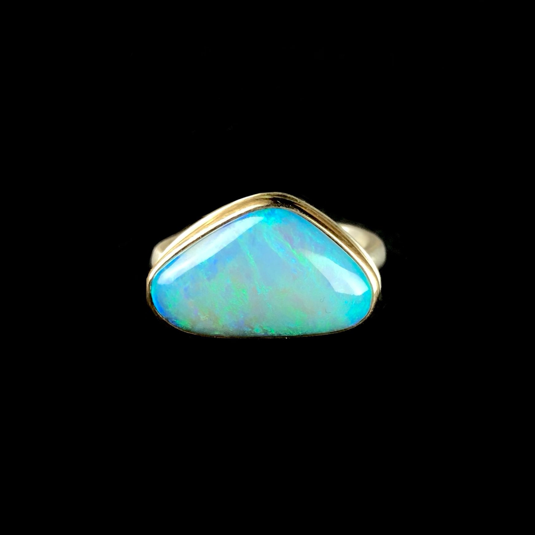Front view of triangular shaped green and blue opal stone ring