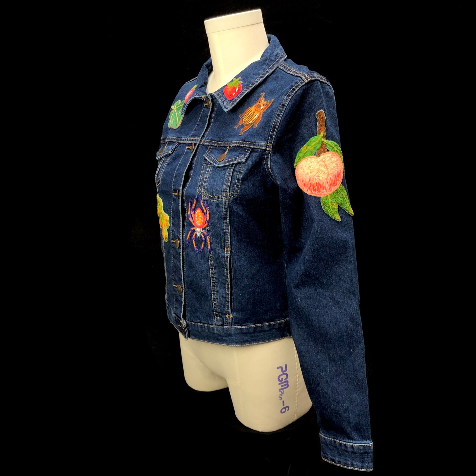 Left side view of peach, beetle and spider patches on Mushroom Jacket