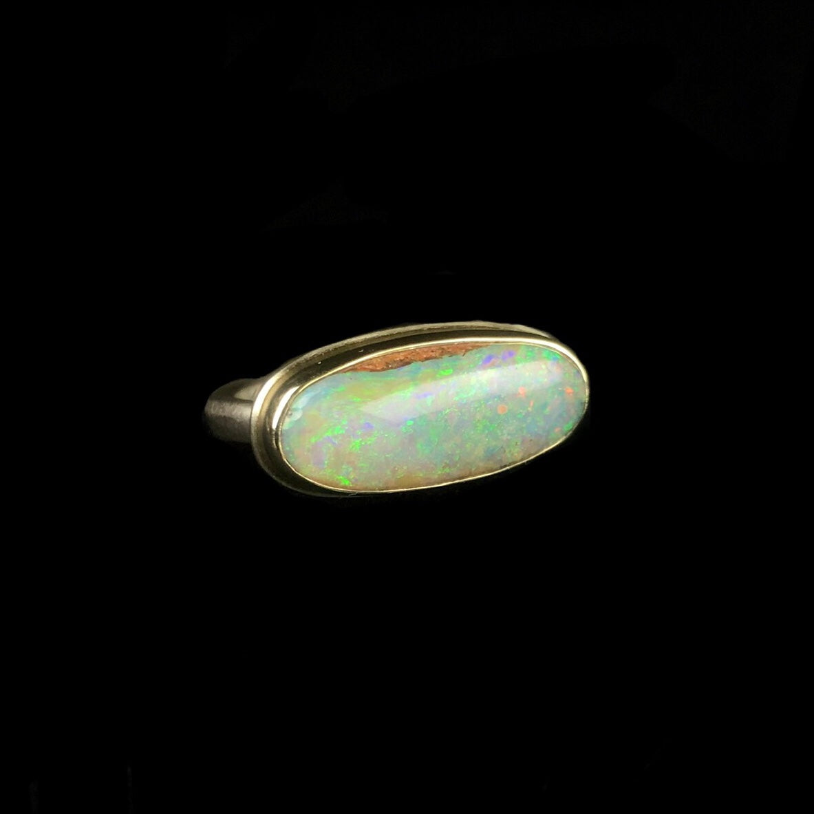 Iridescent green, violet purple and pink confetti of color in opal stone ring 