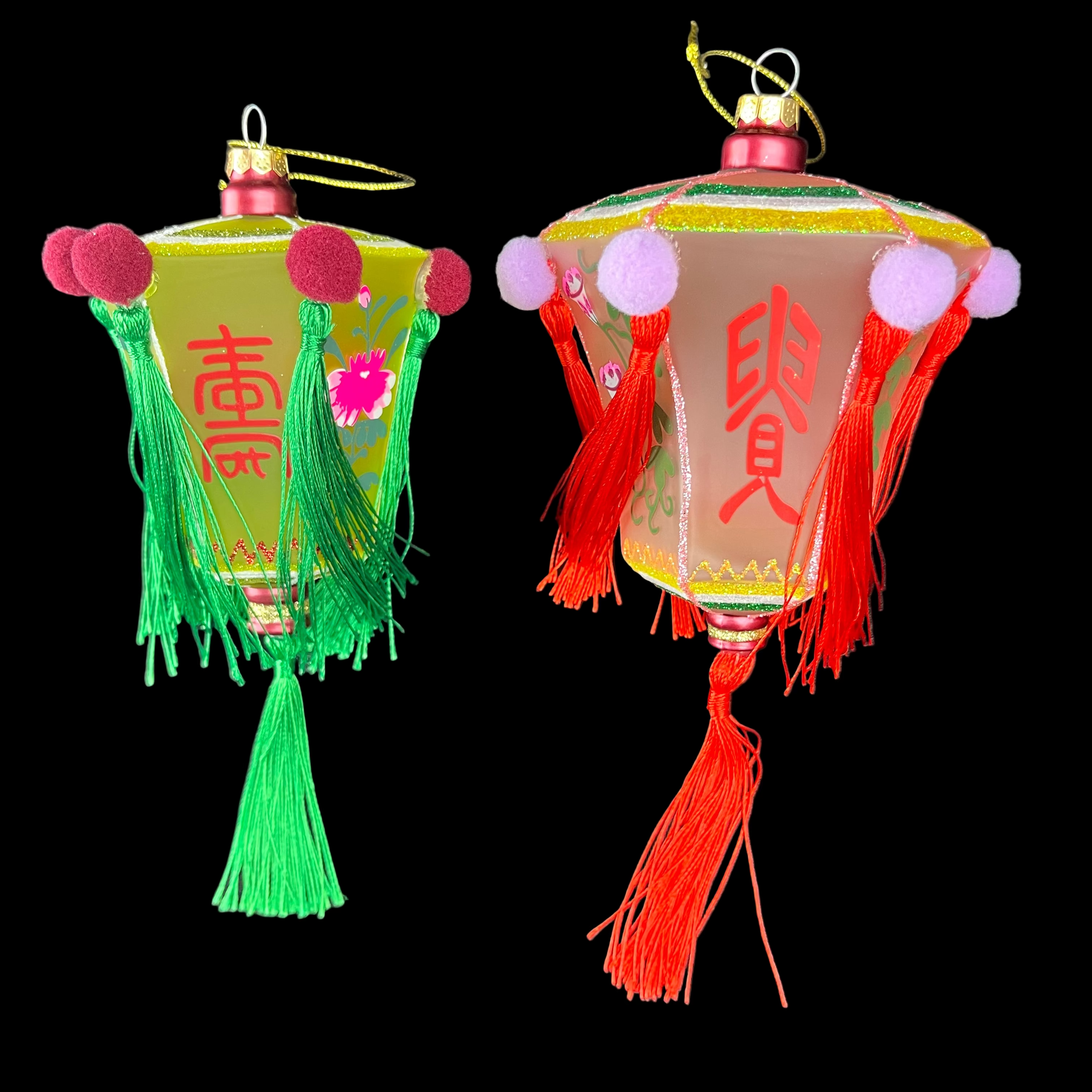 Two colorful lantern decorations with tassels on a dark background