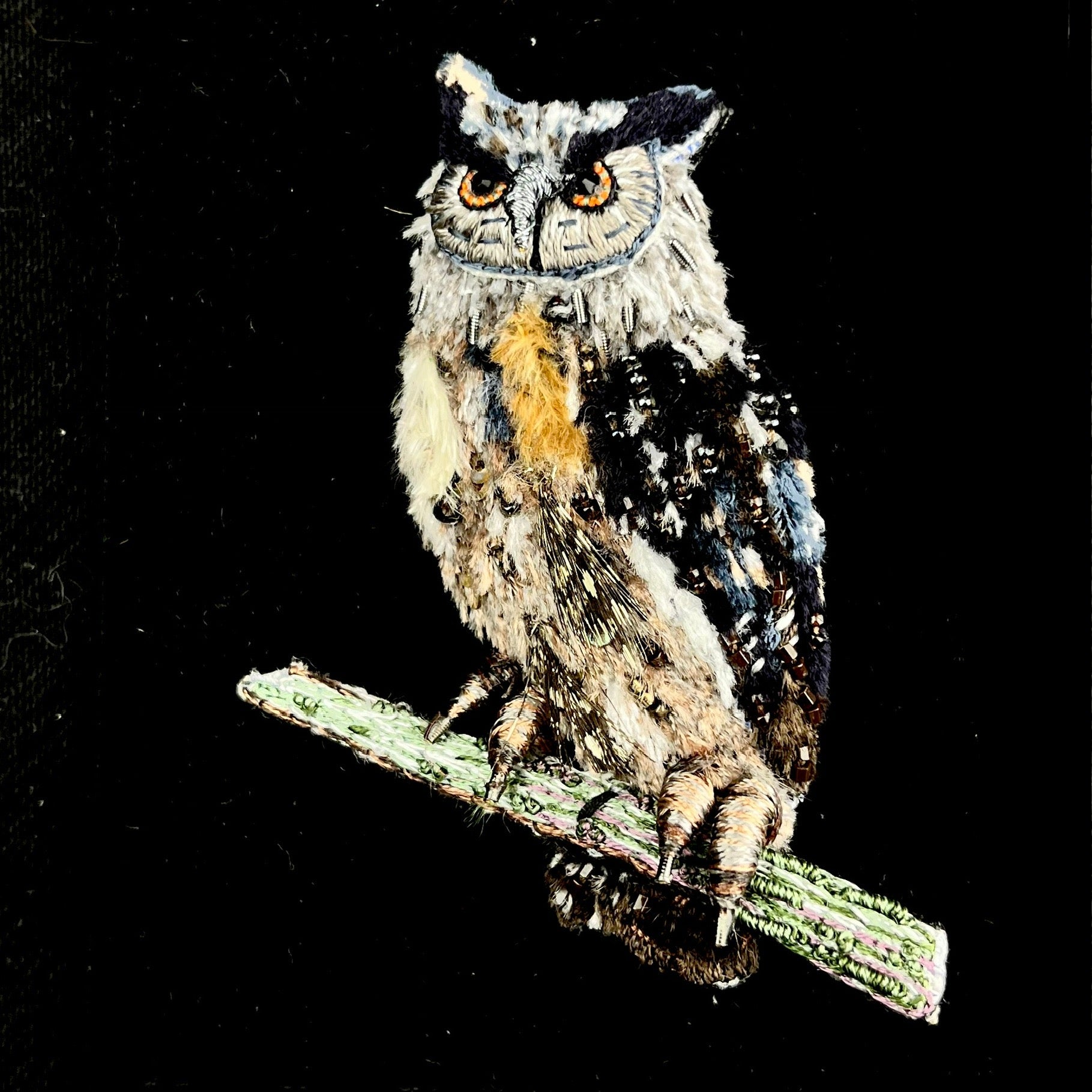 Brown and Blue featherlike thread embroidered owl standing on green branch with sparkling metal and glass bead accents