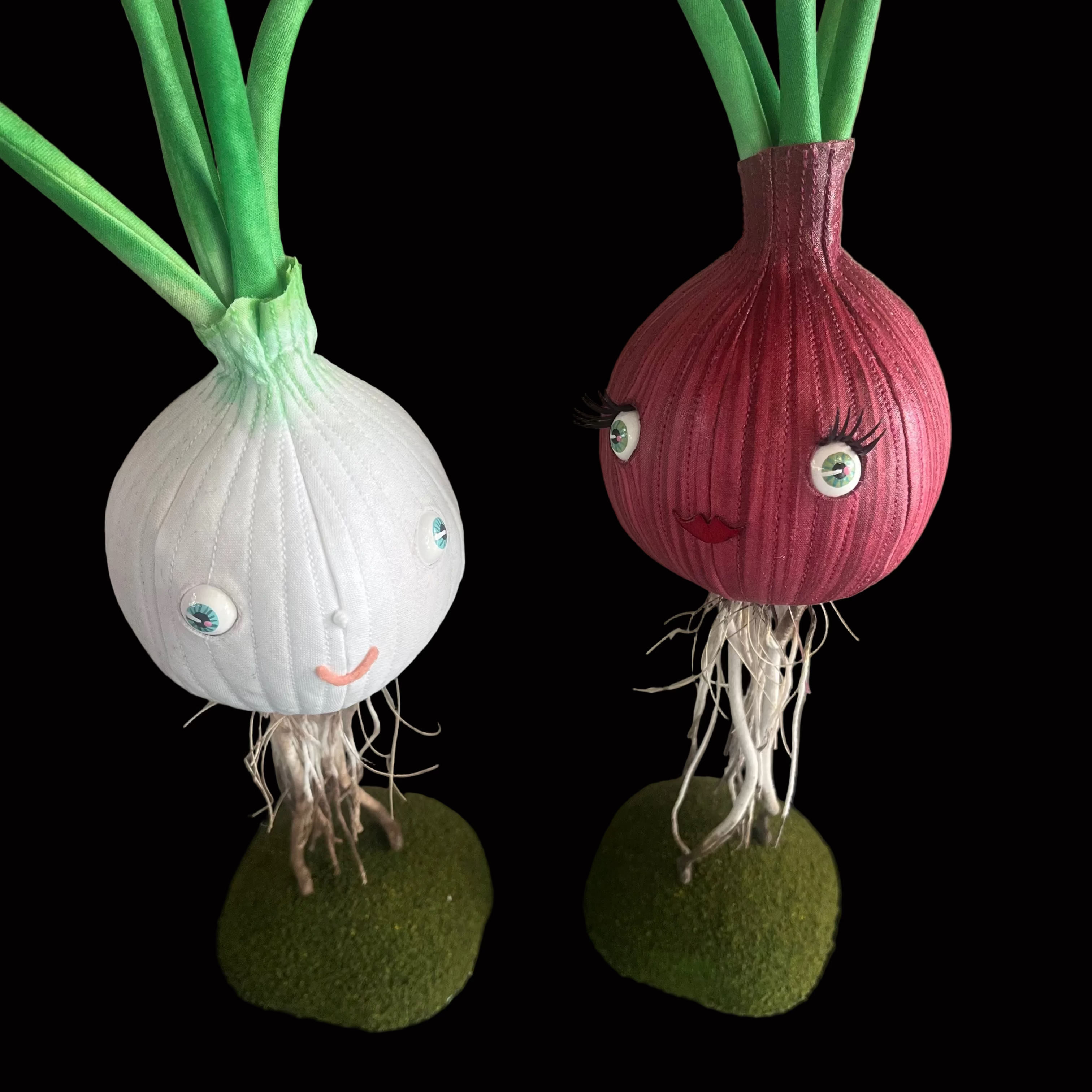 Stuffed fabric red and white onion sculptures with bright blue eyes and happy red lips