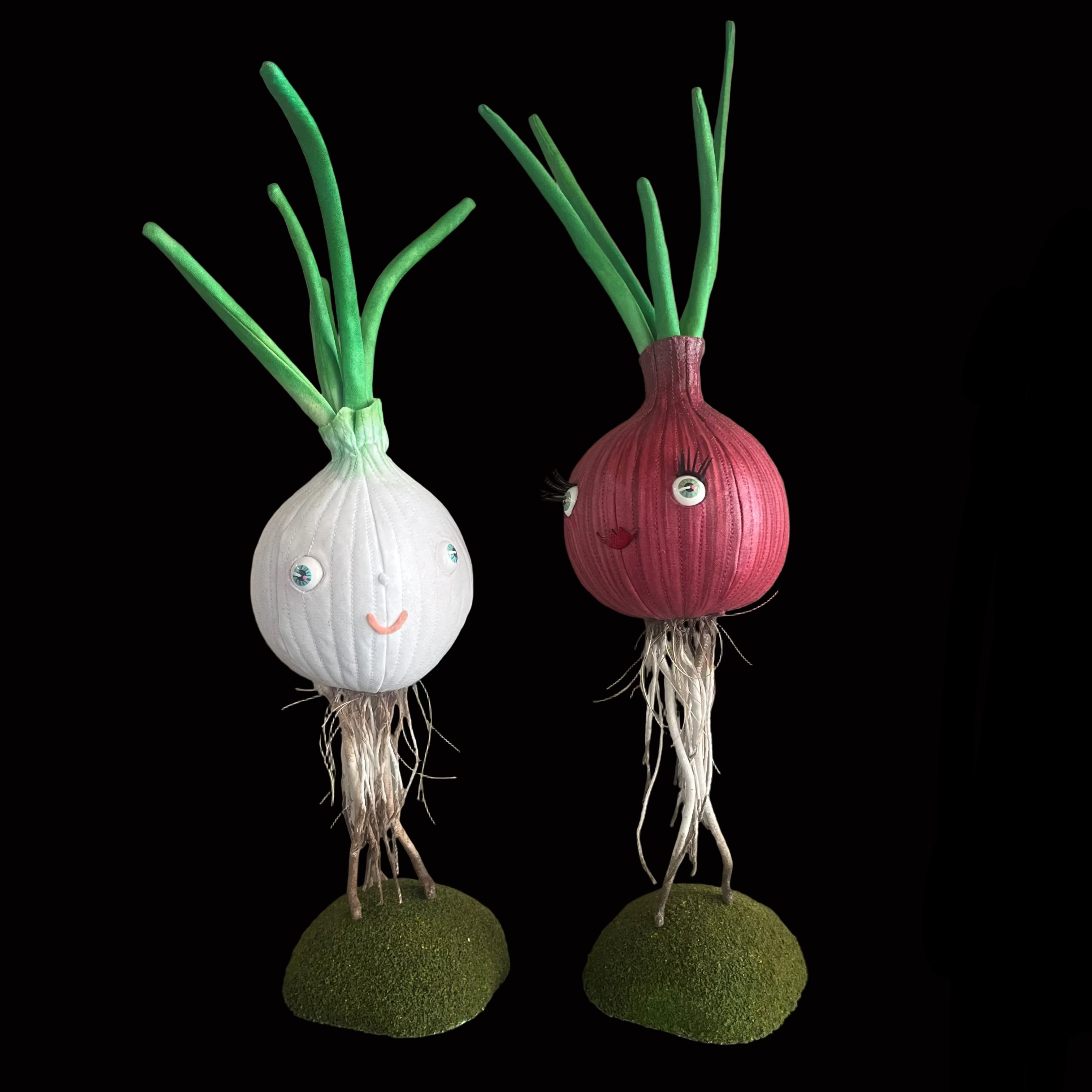 White Onion and Red onion made of fabric and standing on their roots with smiling lips and happy eyes.