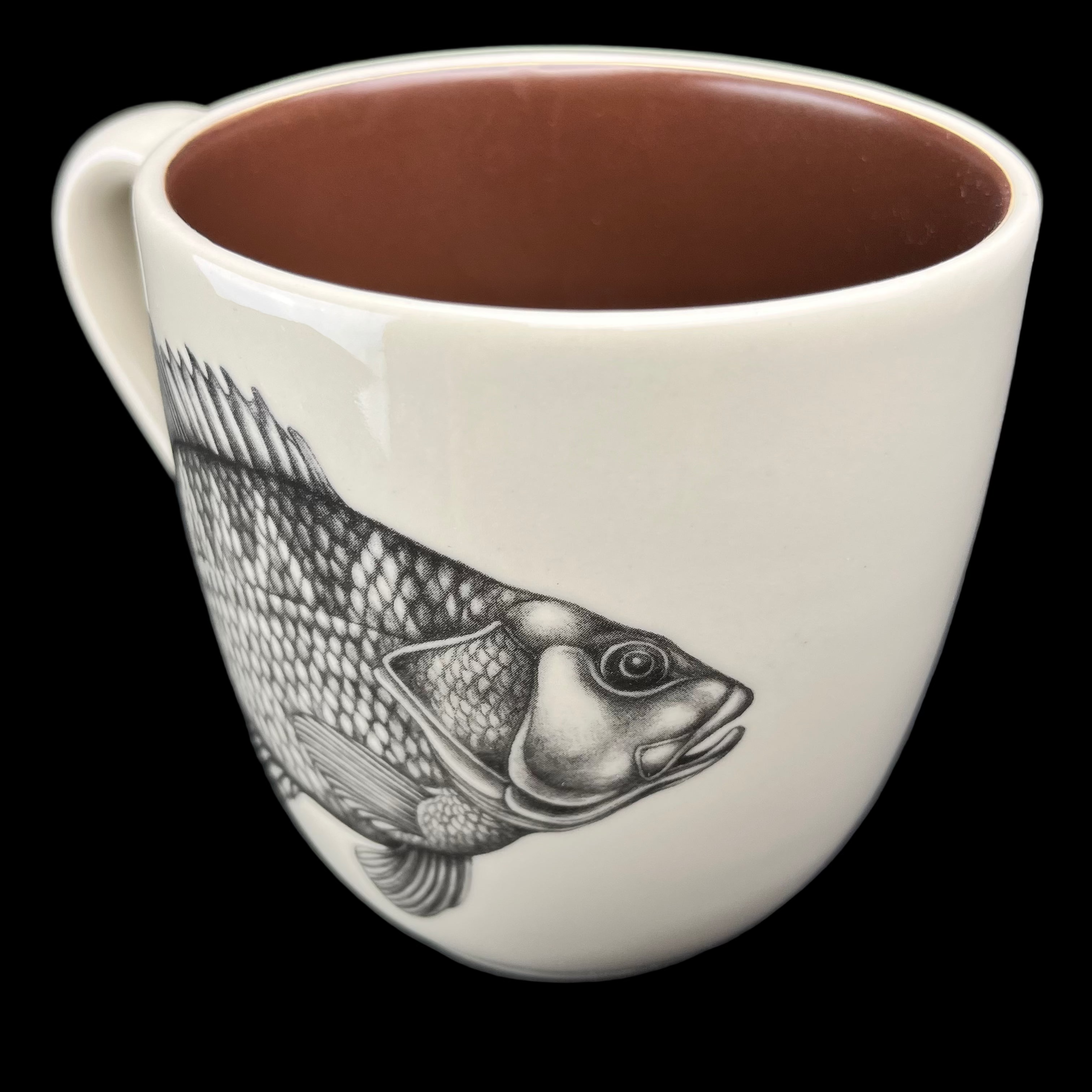 Ceramic mug with fish design on a dark background