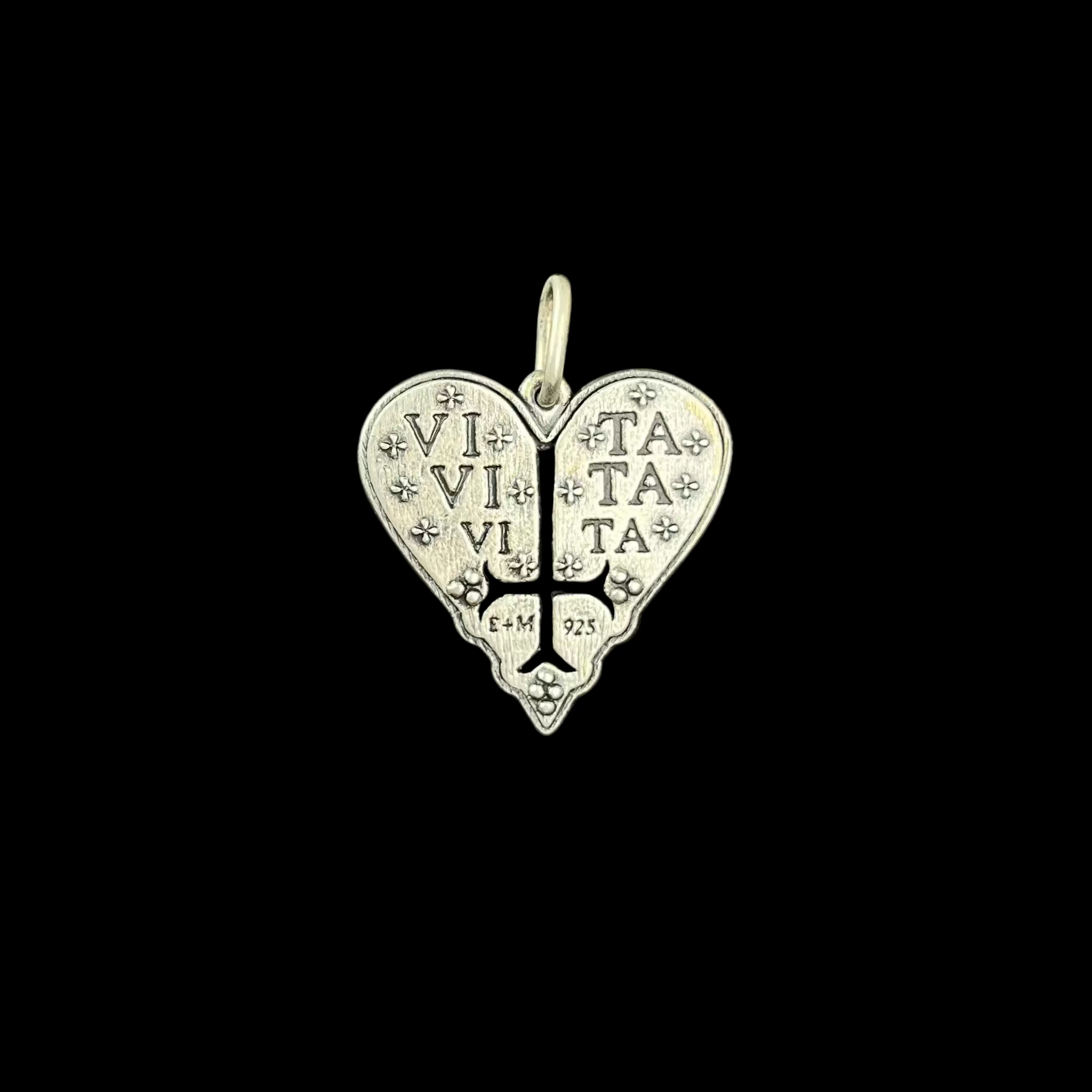 Silver heart-shaped pendant with engraved text on a black background