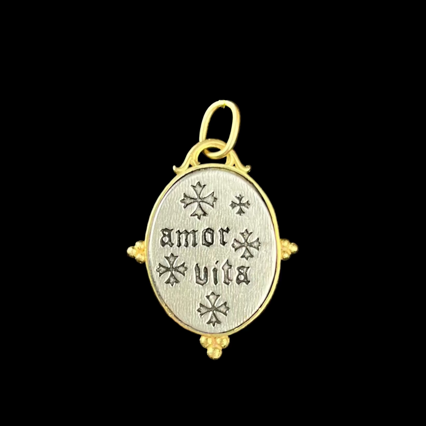 Medallion with 'amor vita' text on a black background