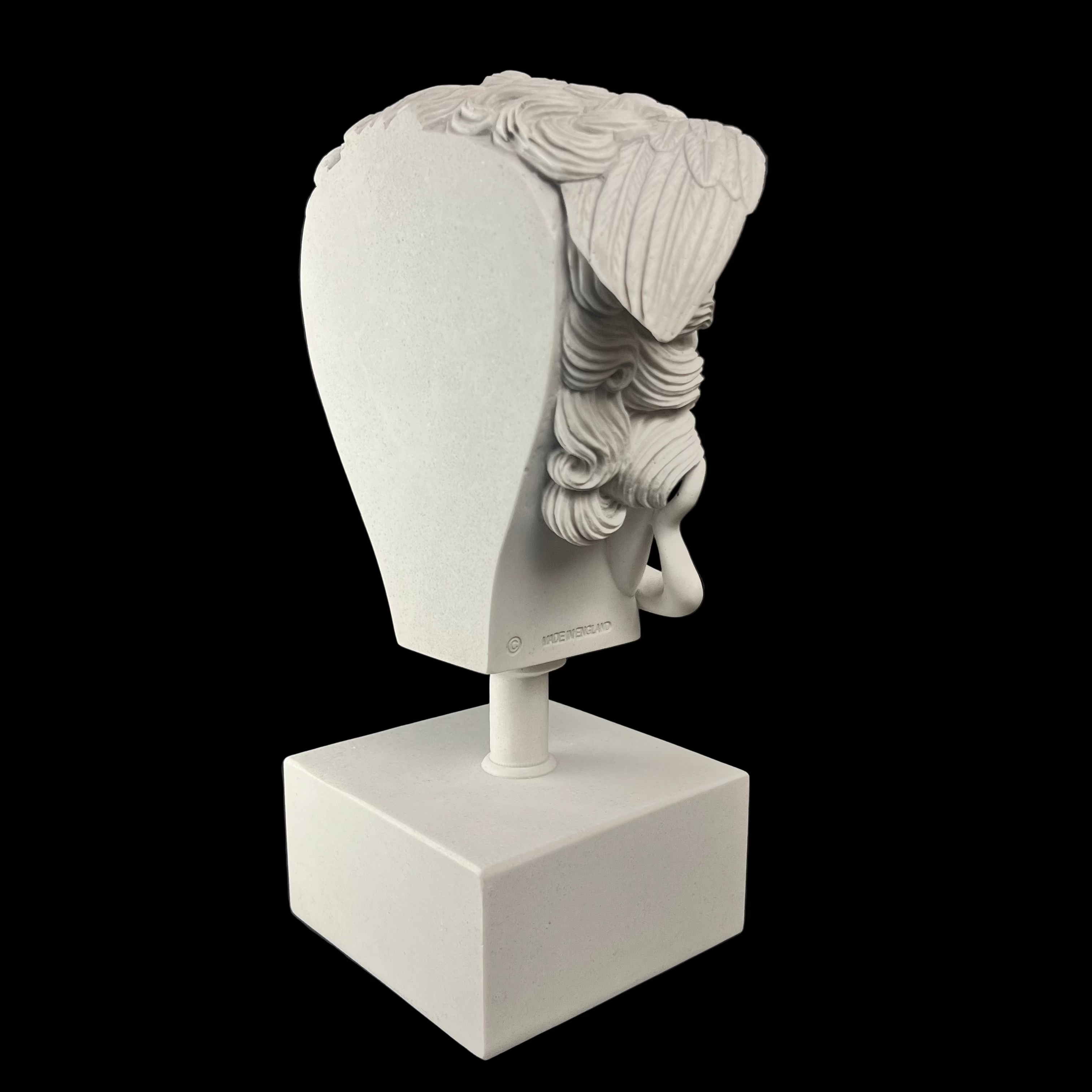 White marble sculpture of a head on a black background