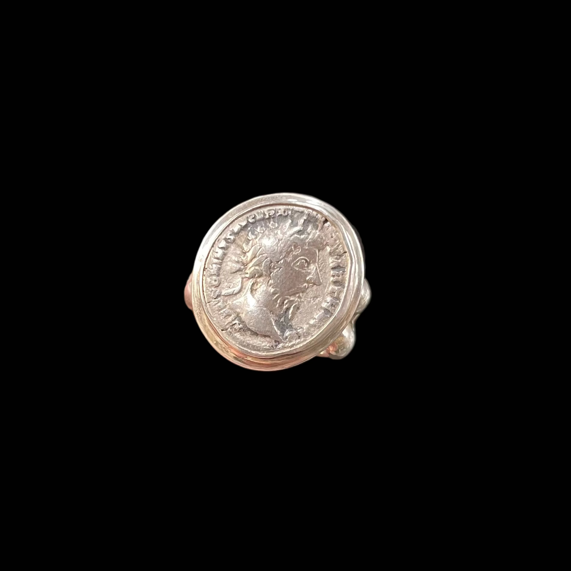 Silver coin set as ring on black background