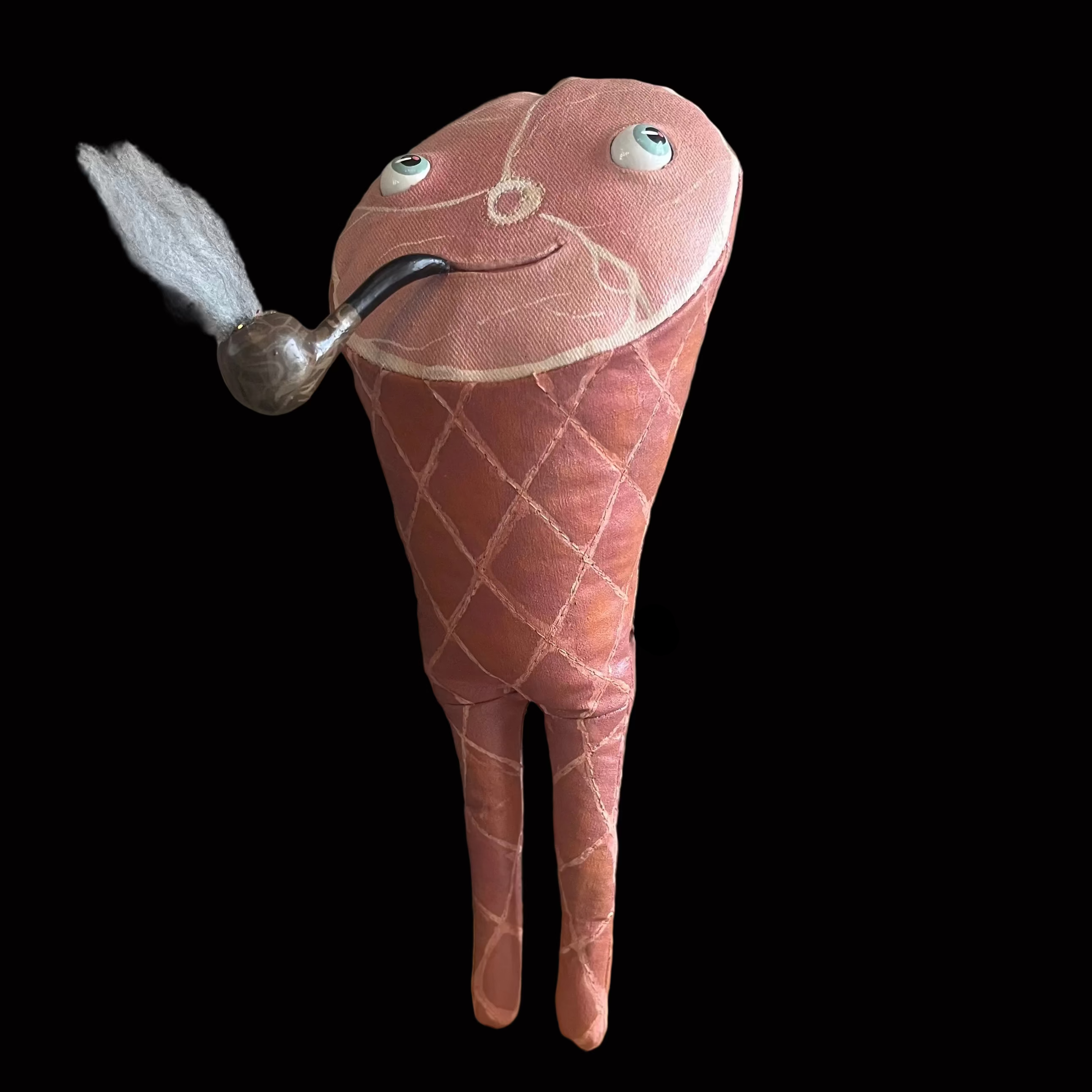 Whimsical smoked ham-shaped decorative figure standing on wooden base against black background with a smoking pipe and smiling face.
