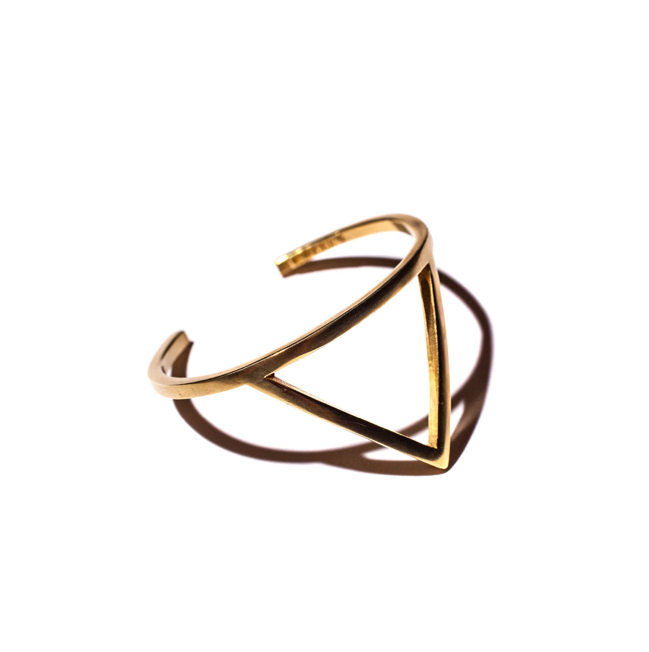 Gold open ring with geometric design on a white background