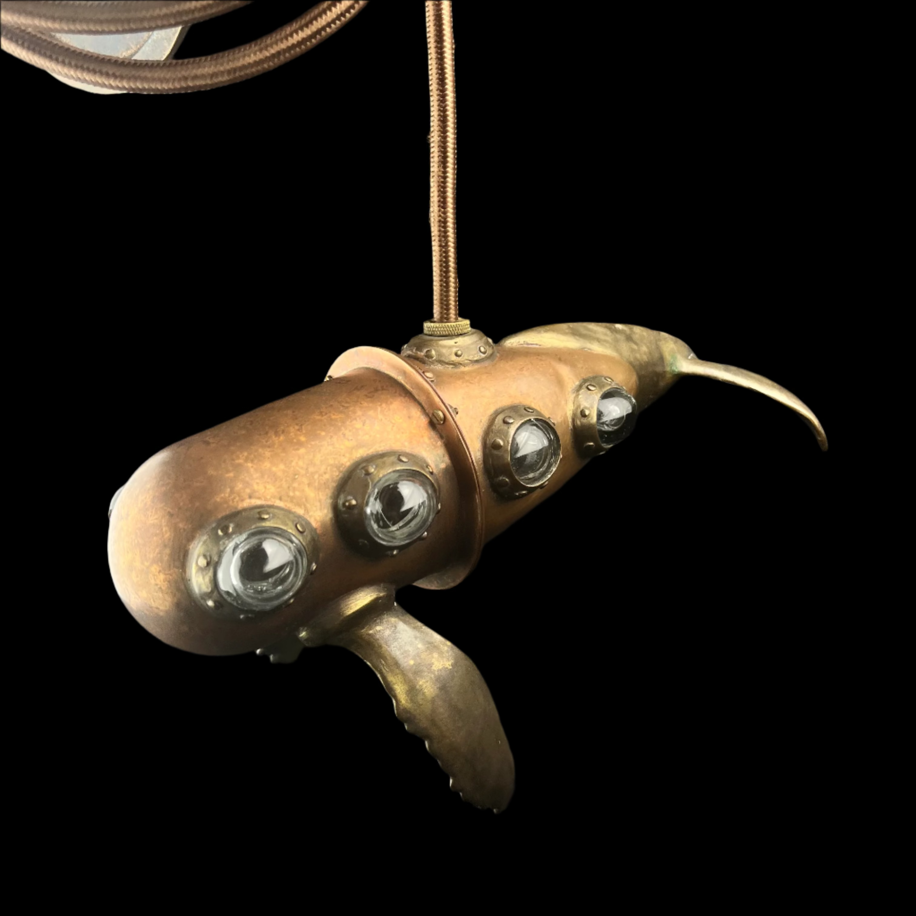 Brass octopus pendant with embedded lights on a dark background