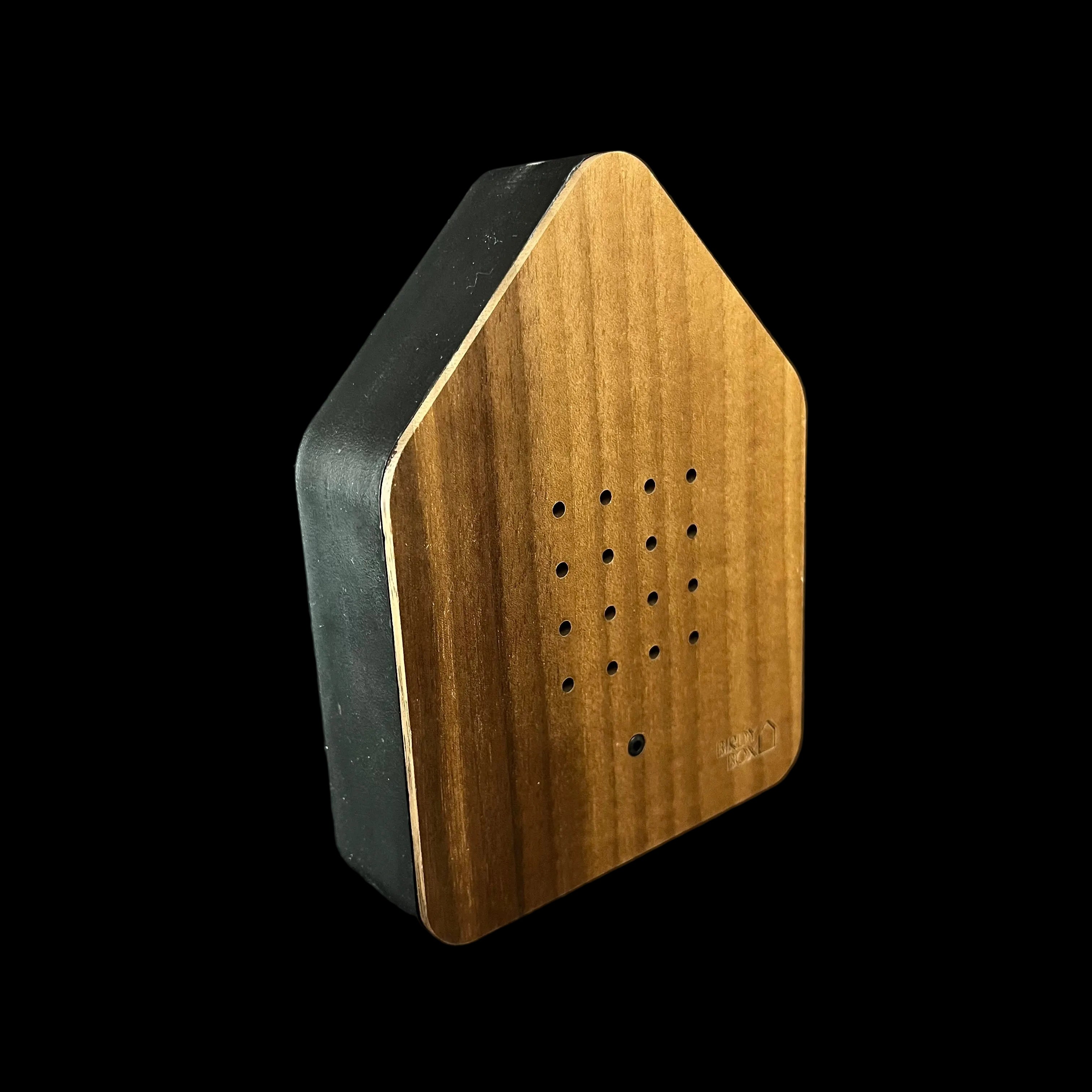 Wooden and black rectangular object with a textured surface on a dark background