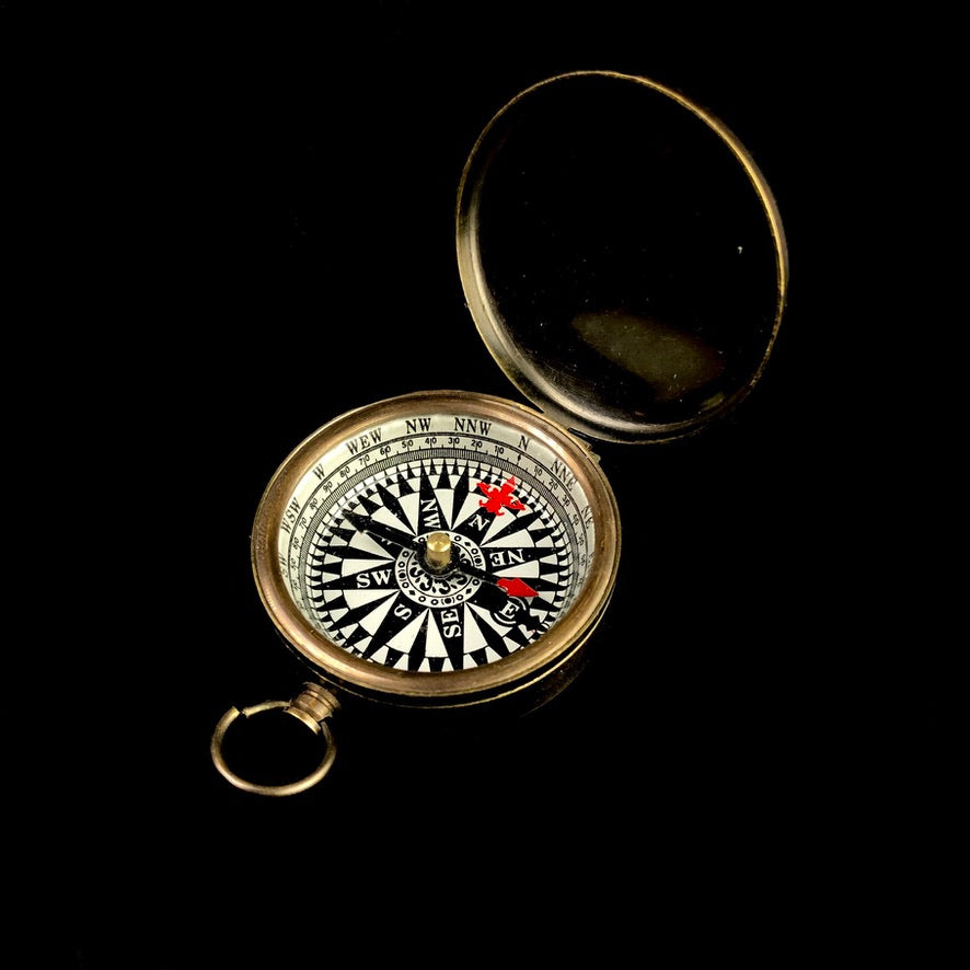 black and white compass face in round bronze case with lid up