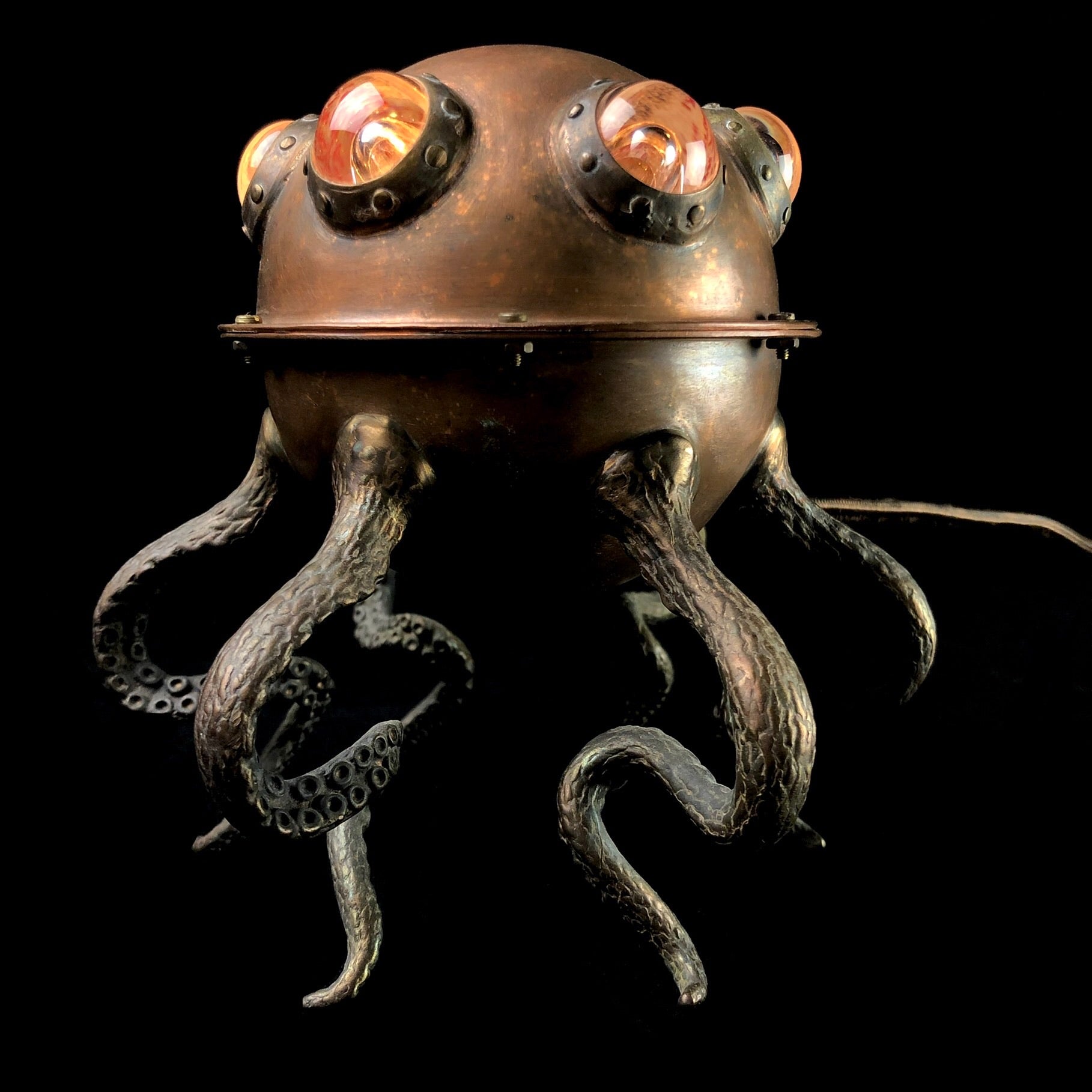 A copper lamp with octopus tentacles on black background