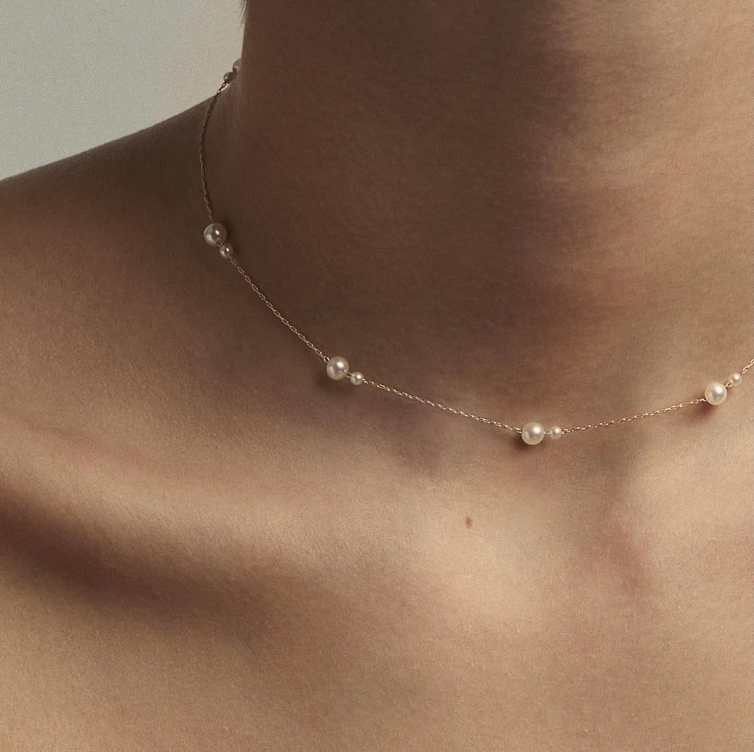 Pearl and gold chain chocker necklace on models neck.