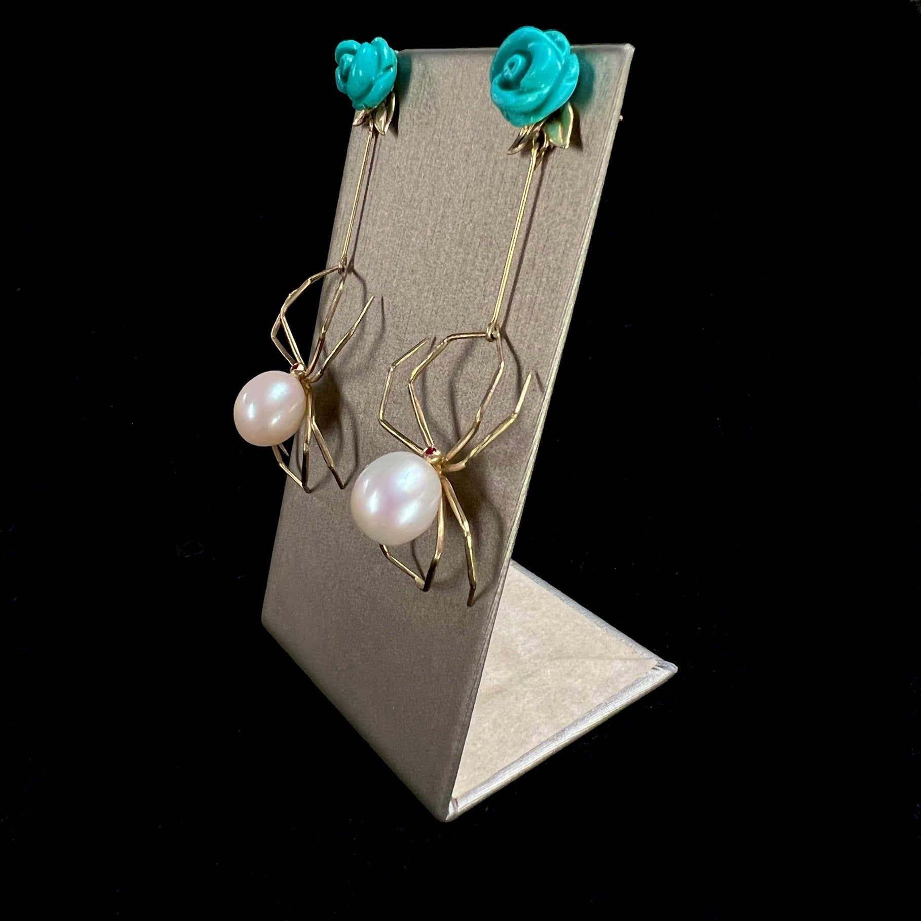 Side view of Turquoise and Pearl Spider Earrings on display stand