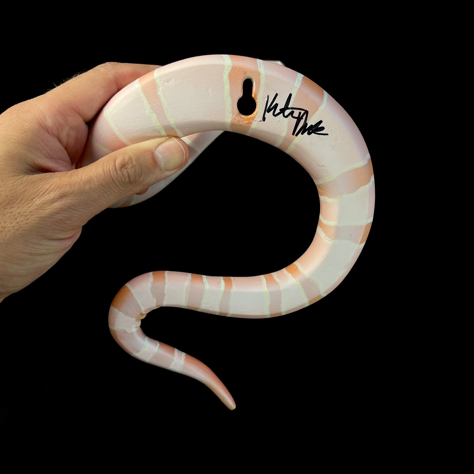Back view of snake displaying wall hanging apparatus and artists signature