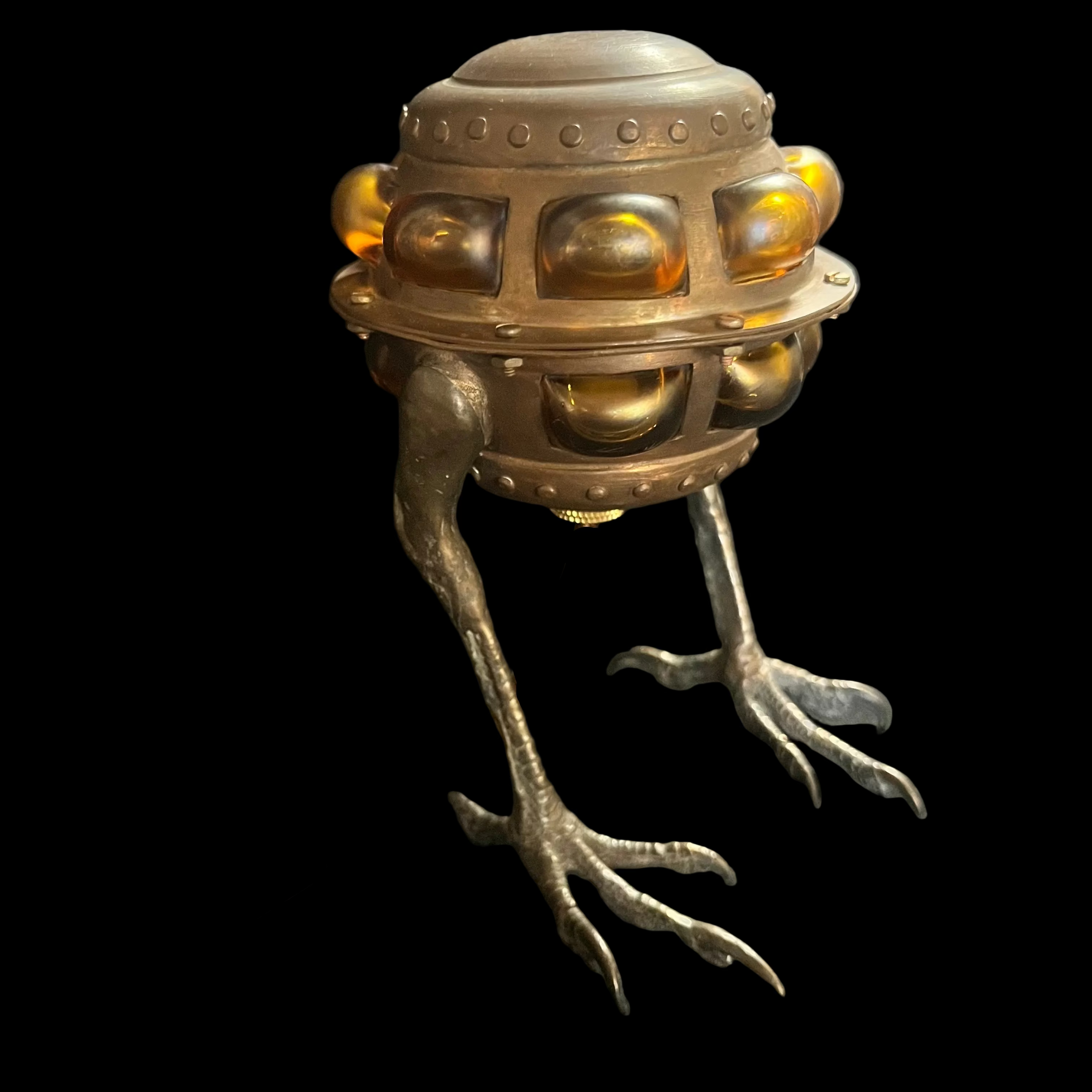 Metallic creature with a lamp-like head on a dark background