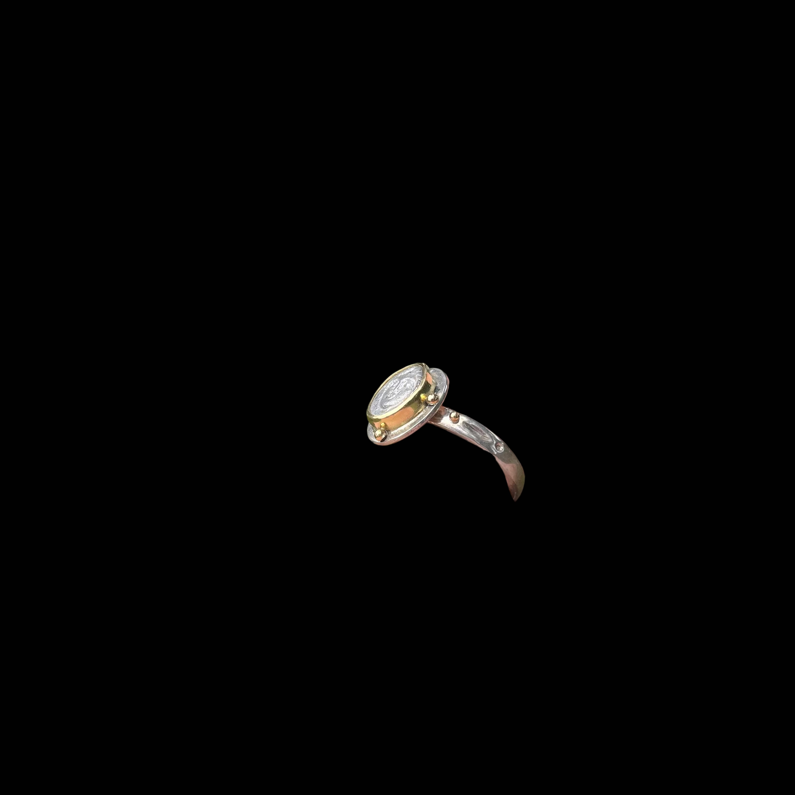 Side view of silver ring on black background