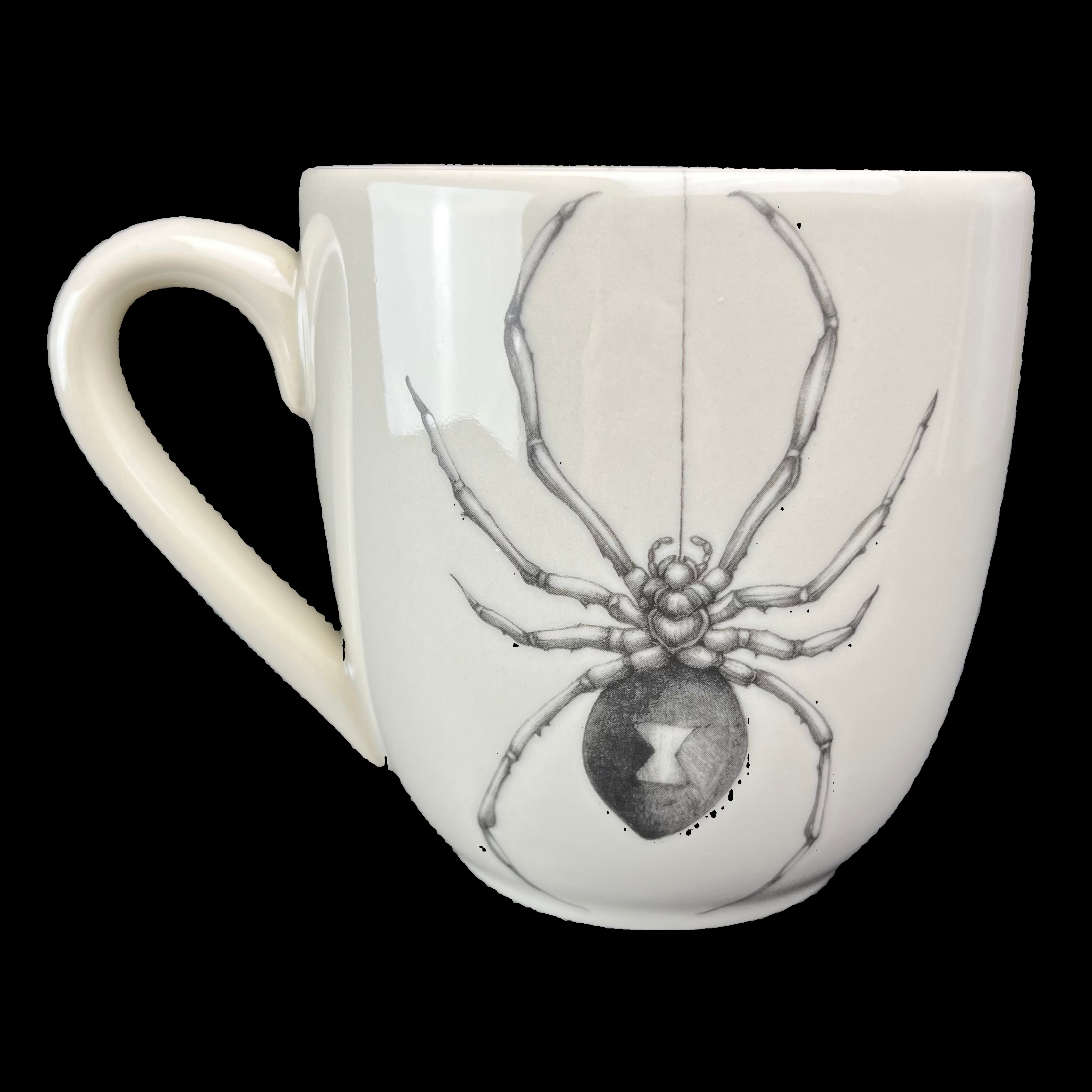 White mug with a black and white spider design on a dark background