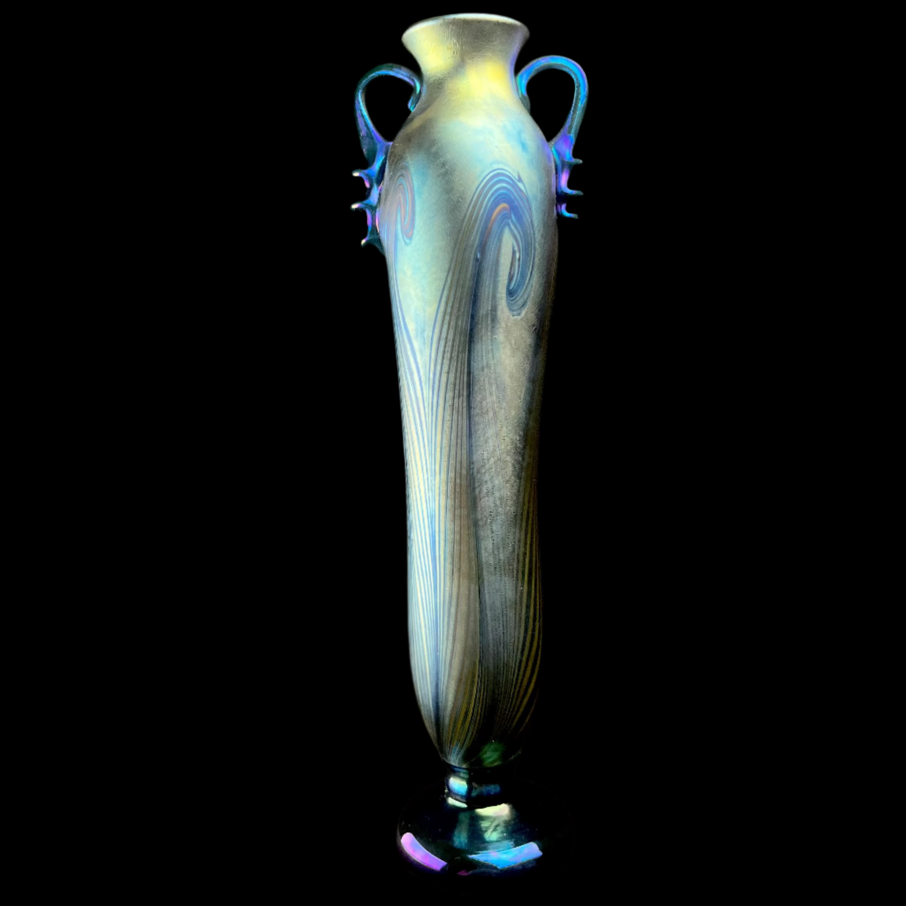 Decorative glass vase with swirling patterns on a dark background