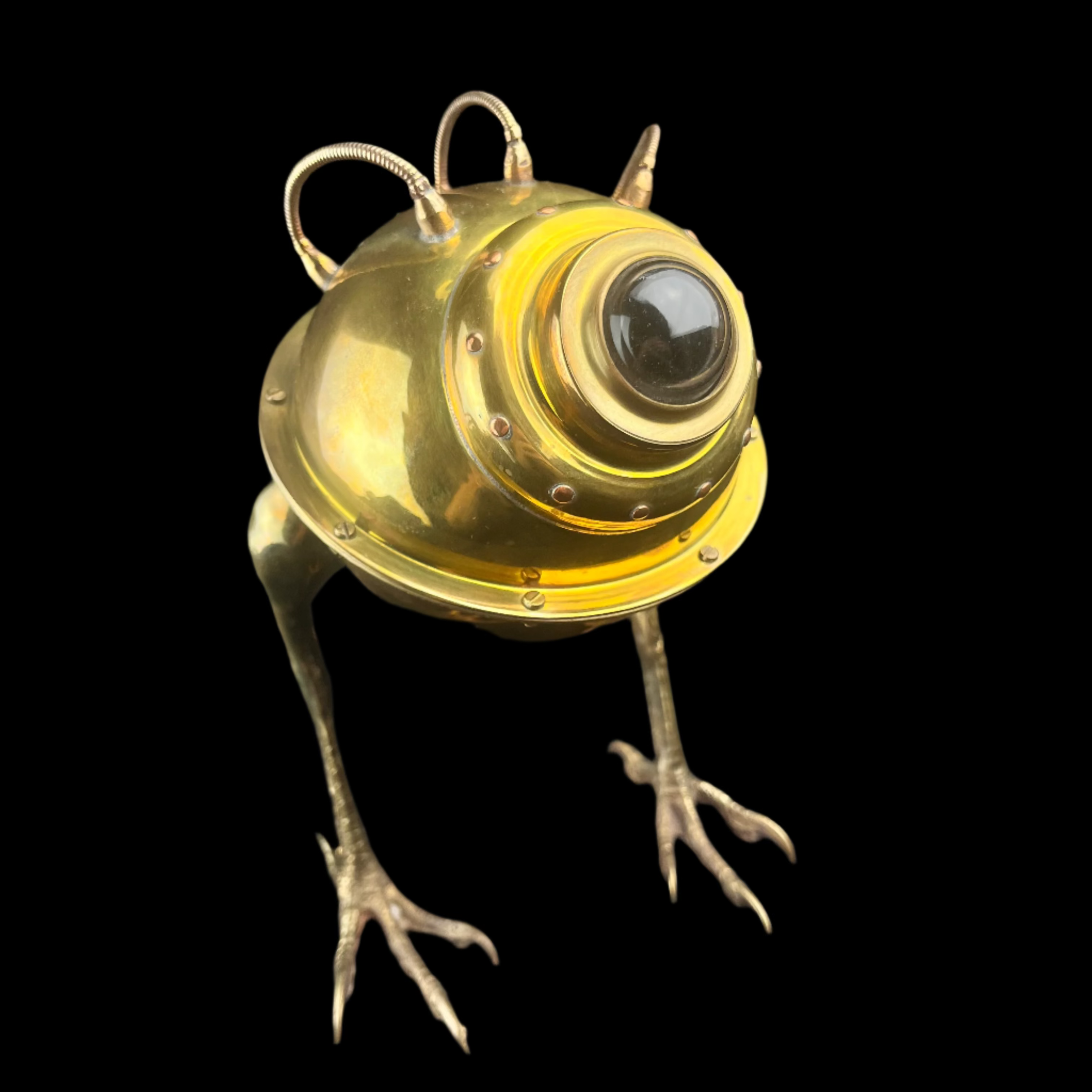 Metallic frog sculpture with a vintage-style lamp on a dark background