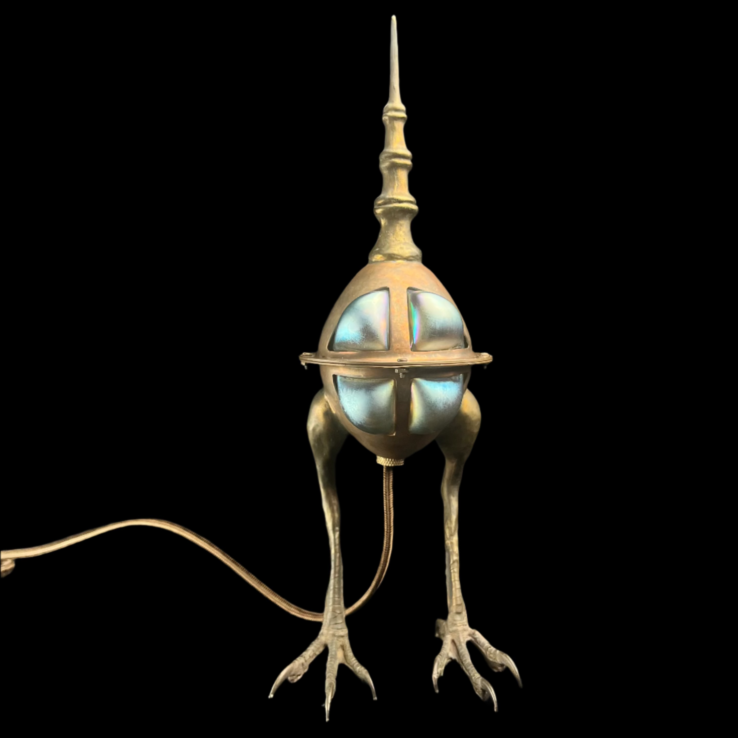 Bronze lamp with the feet of a hawk and frosty blue glass windows on black background