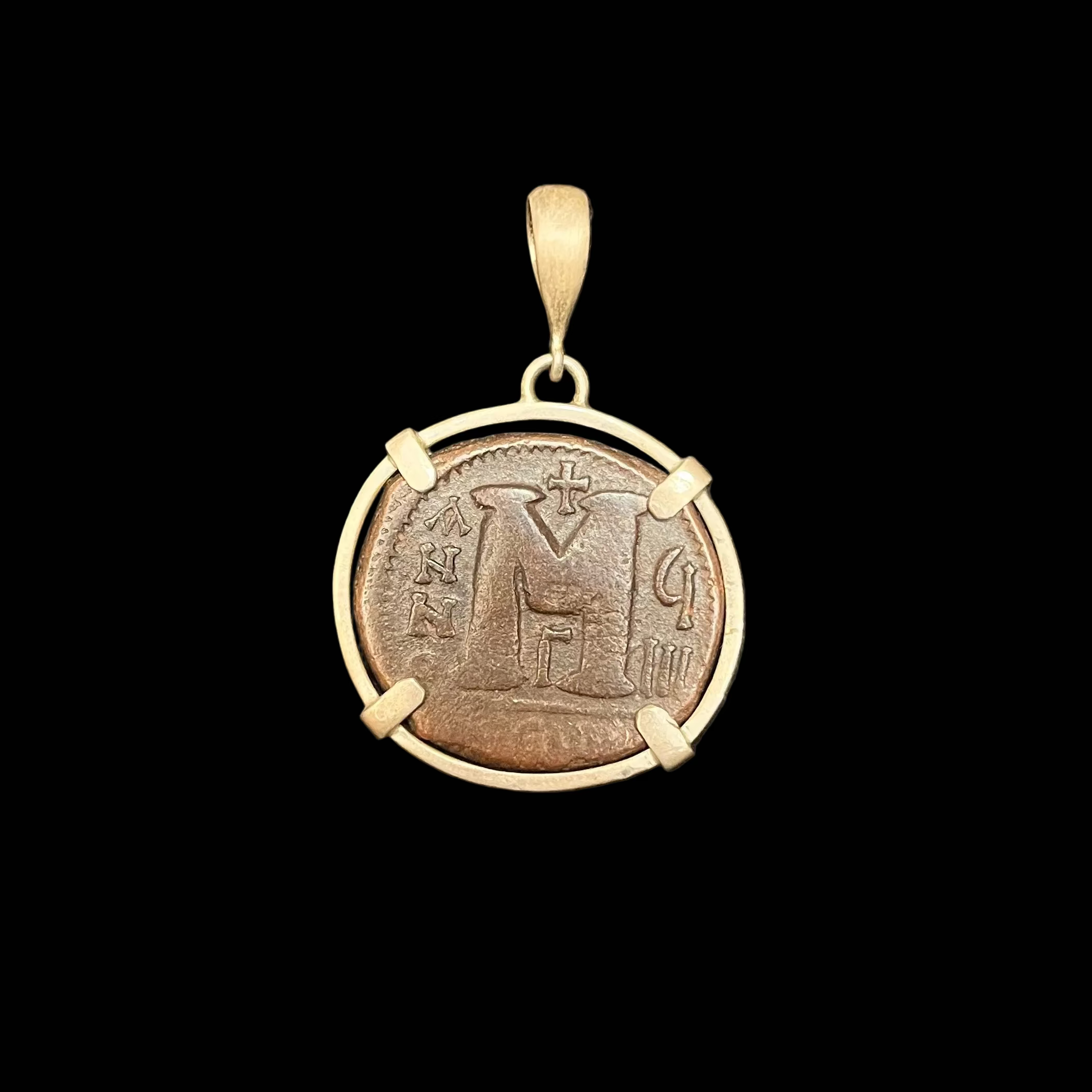 Bronze pendant with gold frame on a black background