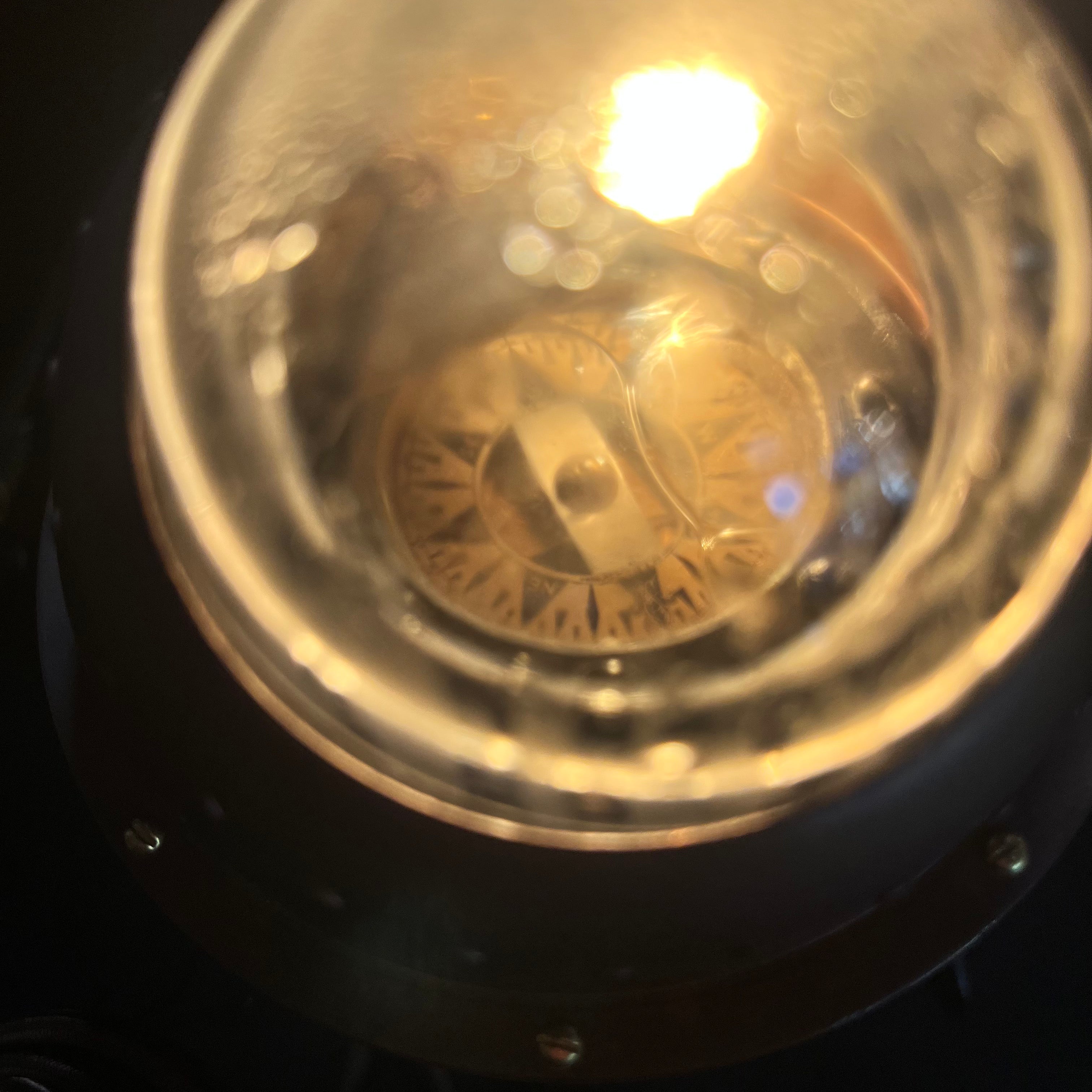 Close-up of a light bulb with a brand logo on a dark background