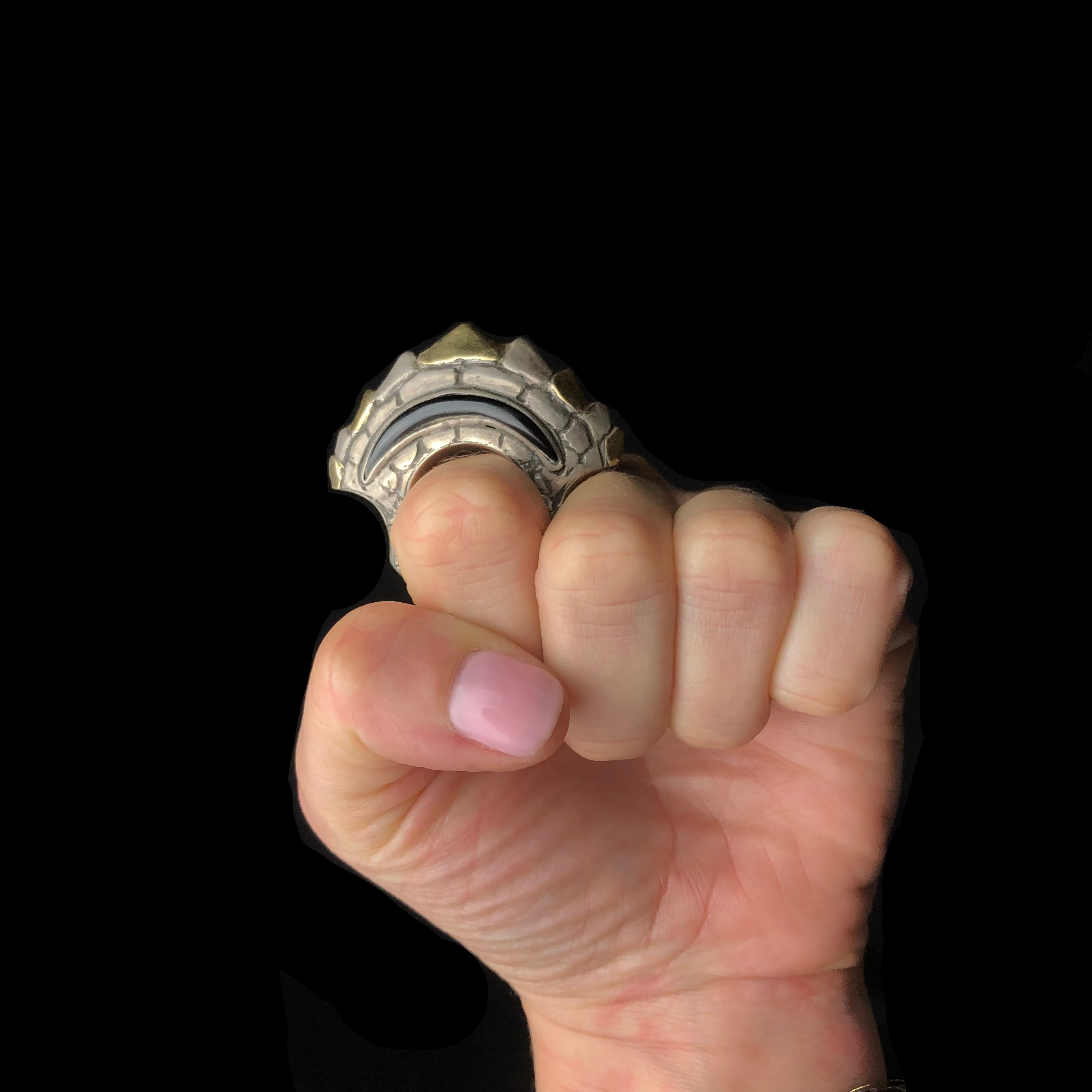 Hand holding a metallic object against a black background